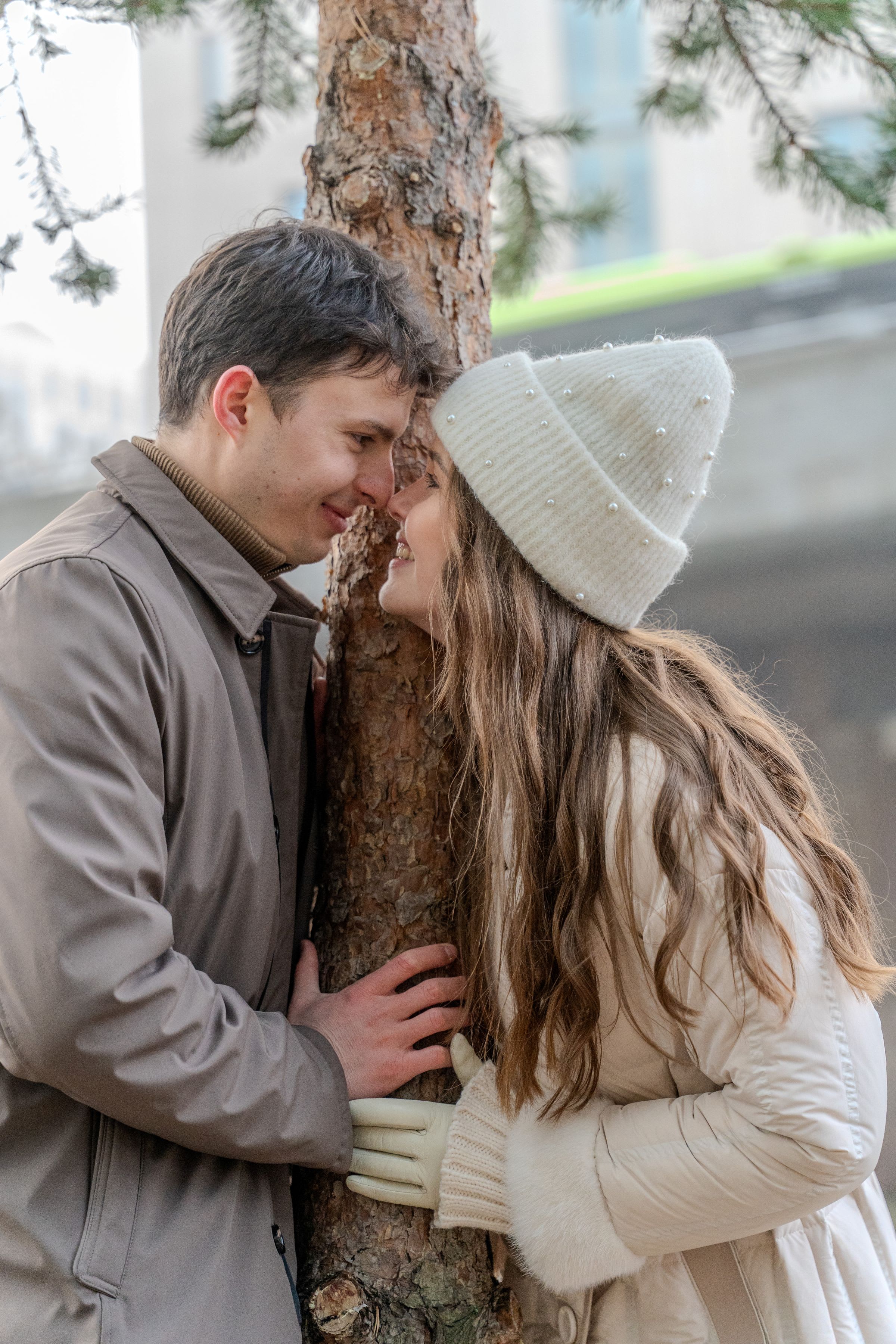Couple hugging a tree in winter