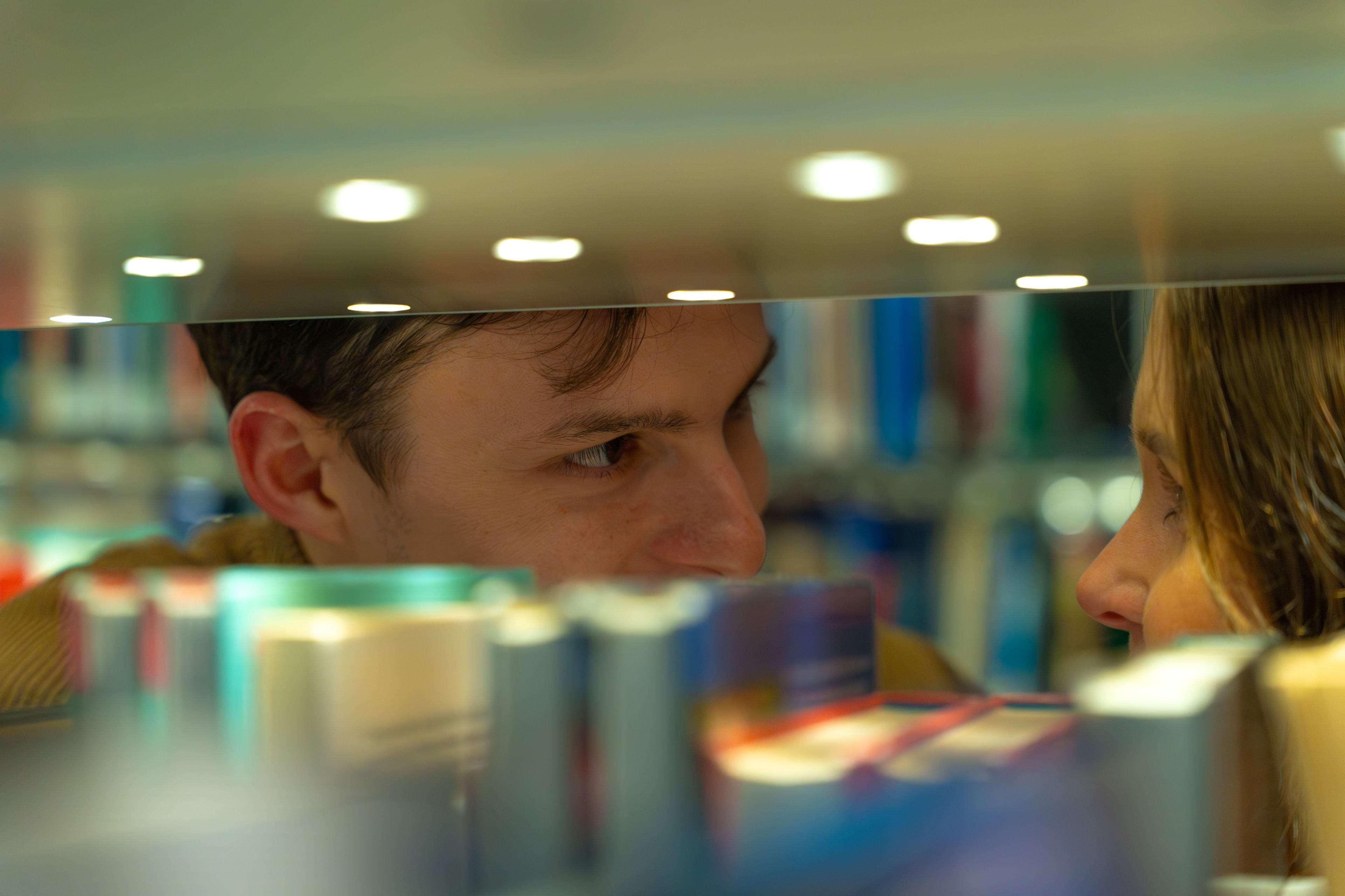 Man and woman looking through bookshelf