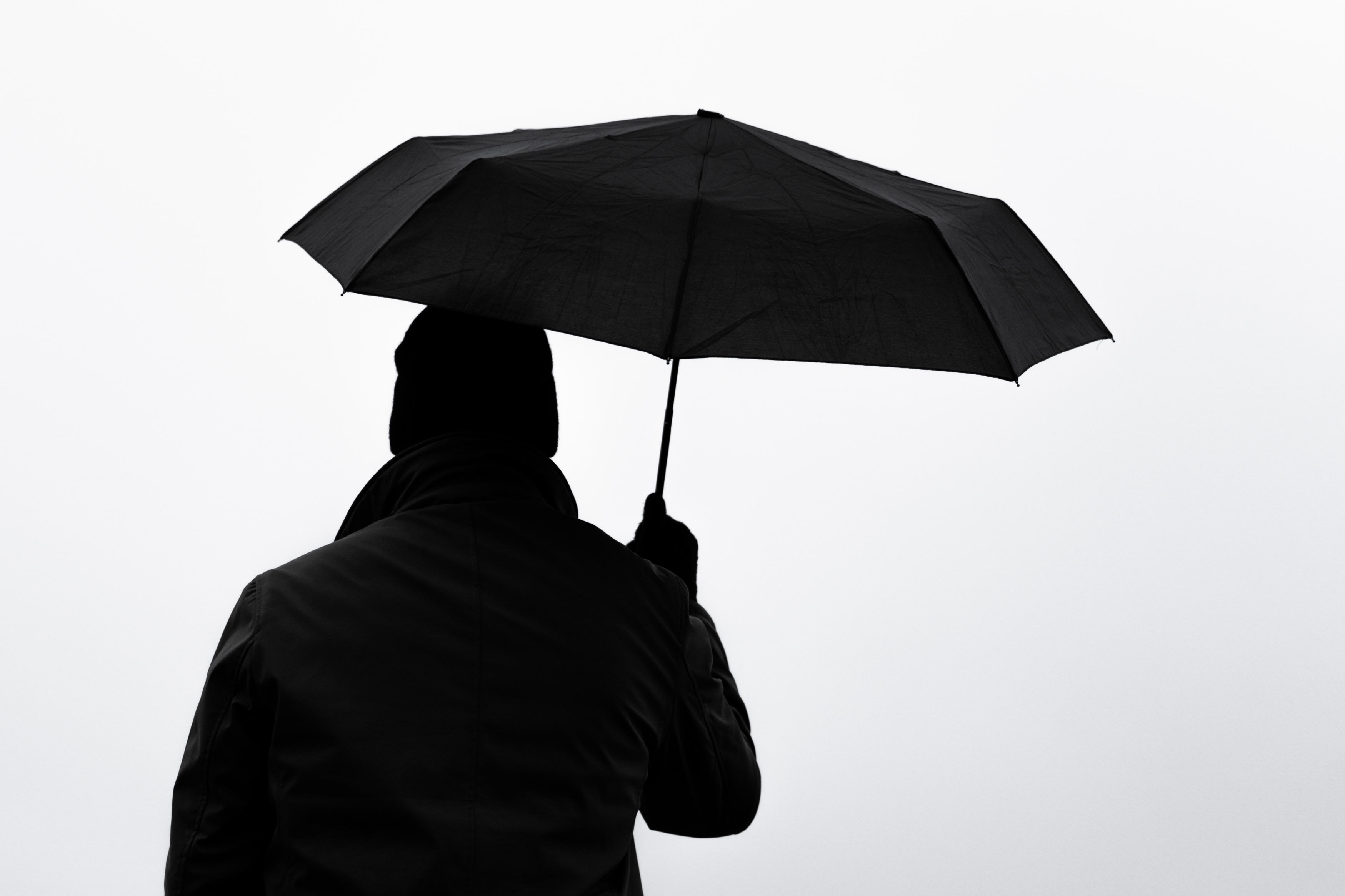 Man with umbrella seen from behind