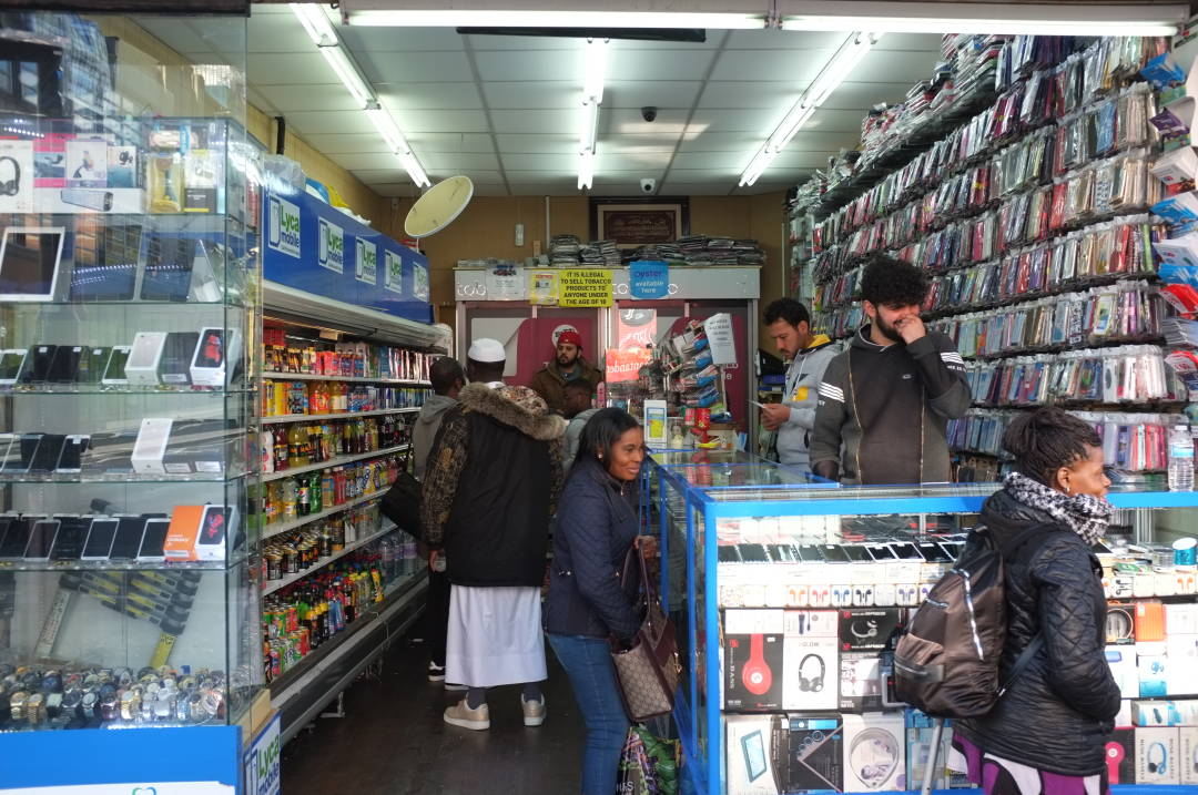 Photo of some people in a shop looking at mobile phone cases