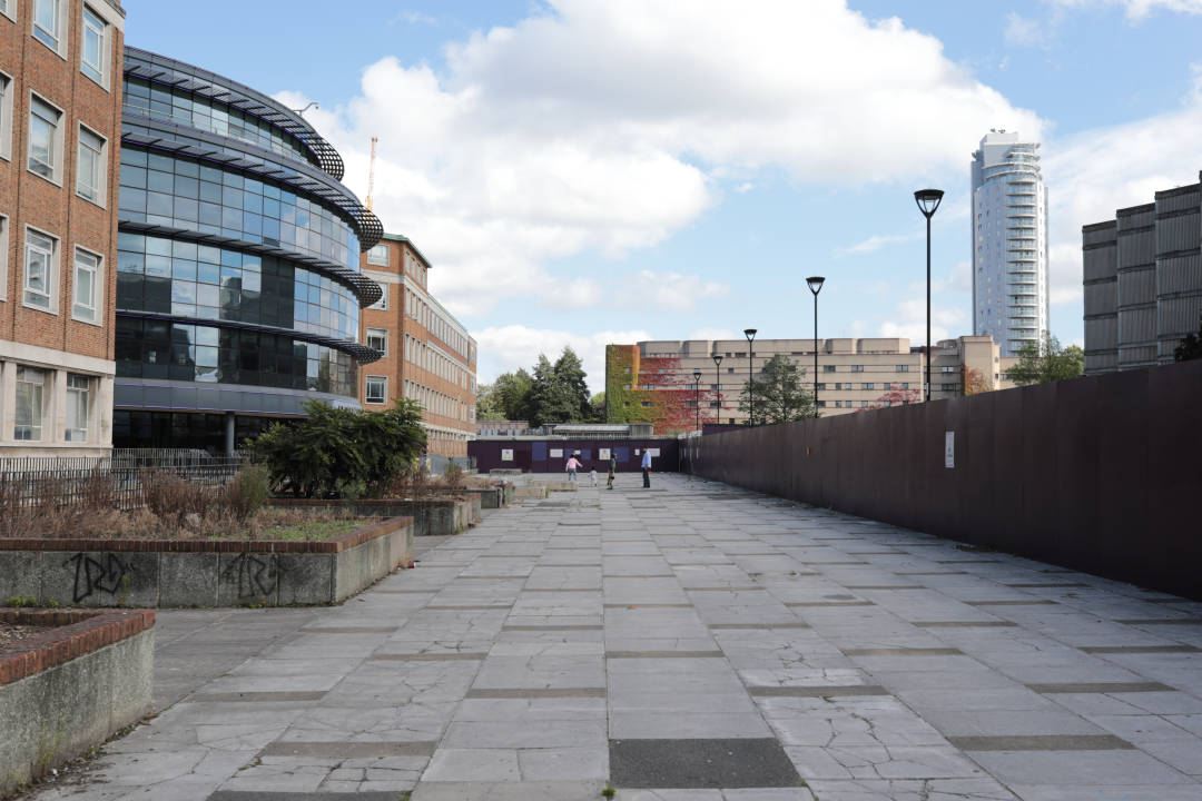 Photo of an old 60s square in concrete, with a building site at the end