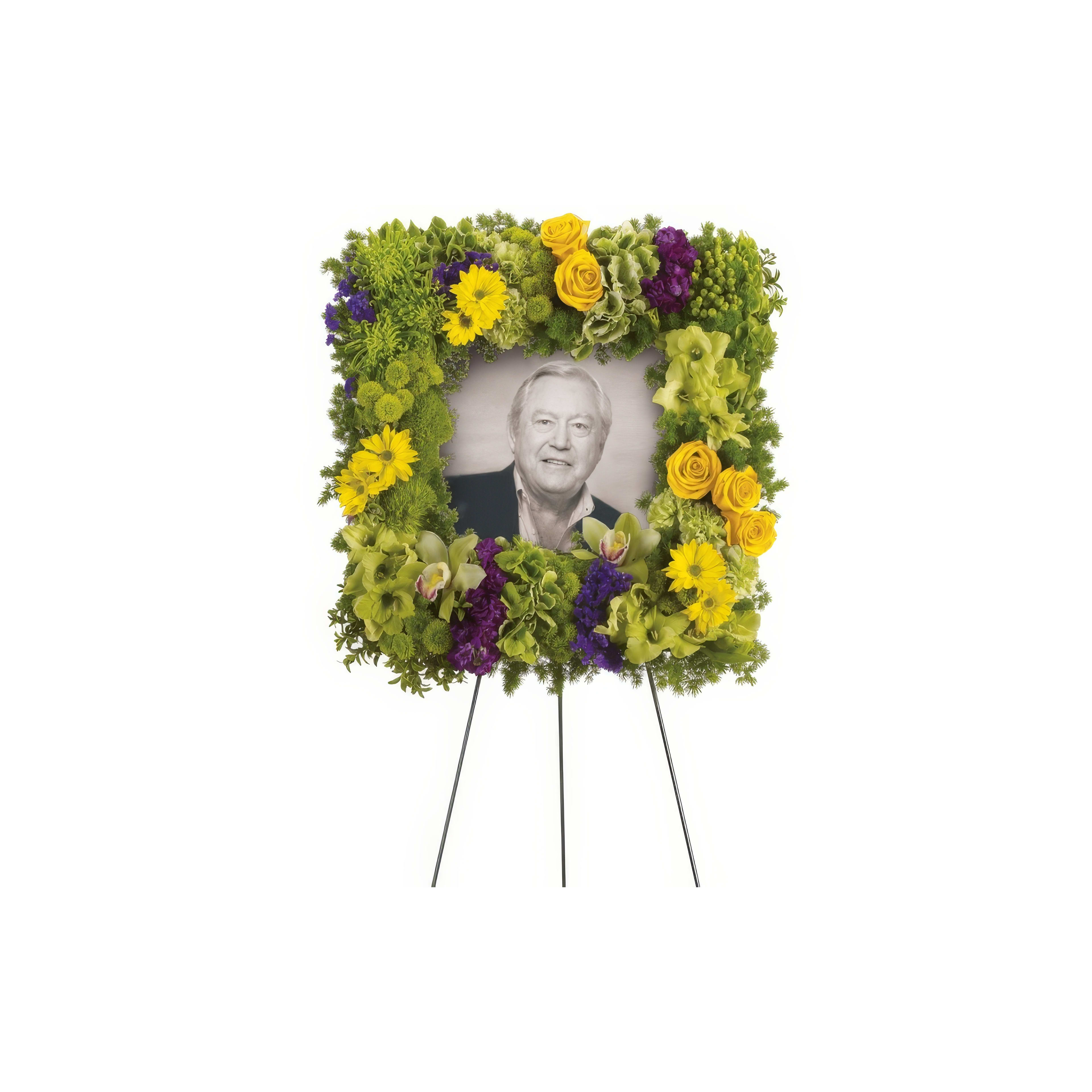 A vibrant floral arrangement surrounds a portrait, honoring a loved one with care and emotion.