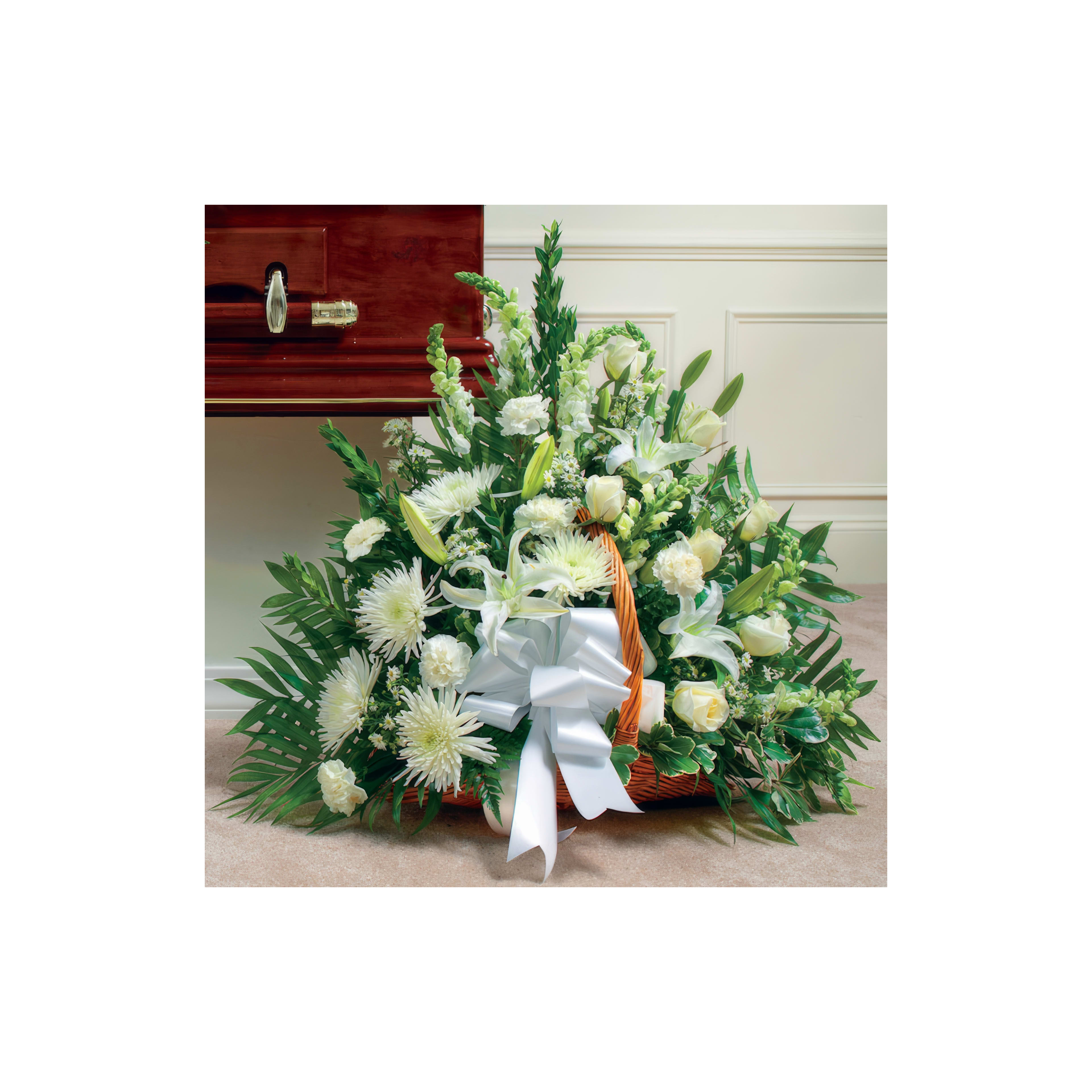Beautiful white flowers arranged in a basket, adorned with a ribbon, meant for a memorial setting.