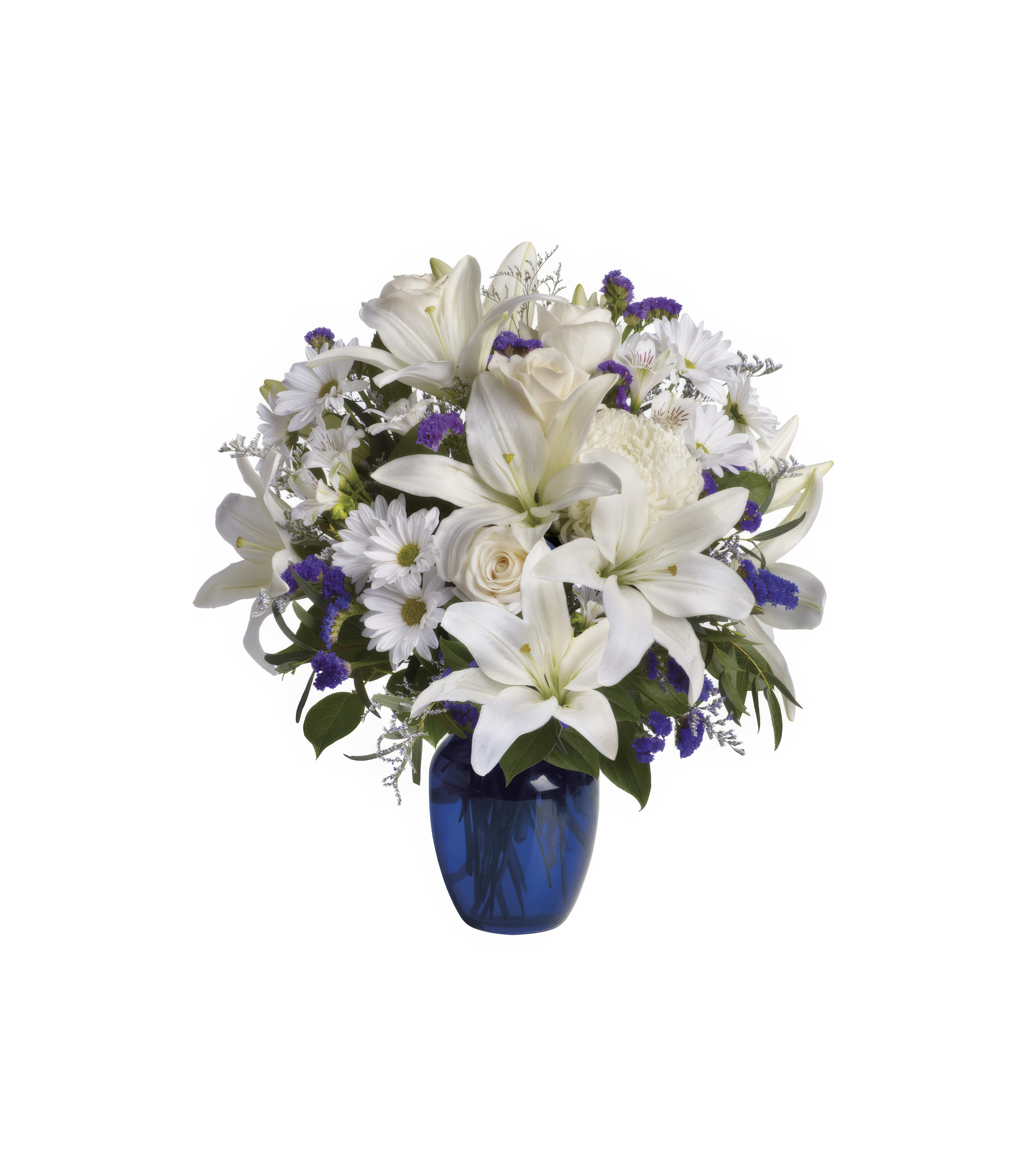 Vibrant flowers including white lilies and daisies fill a blue vase, brightening the space.