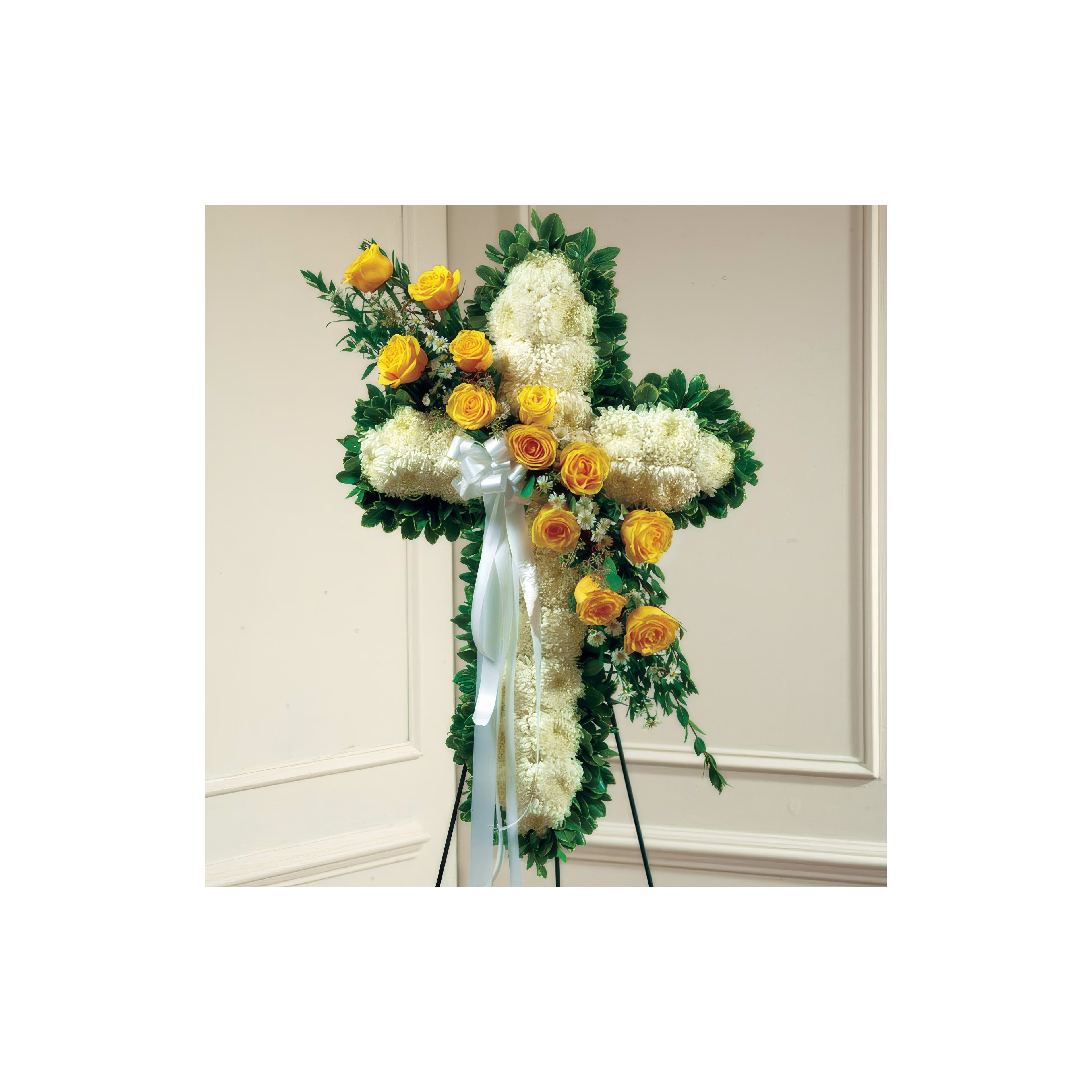 Beautiful floral cross with yellow roses and white blossoms displayed at a memorial event.