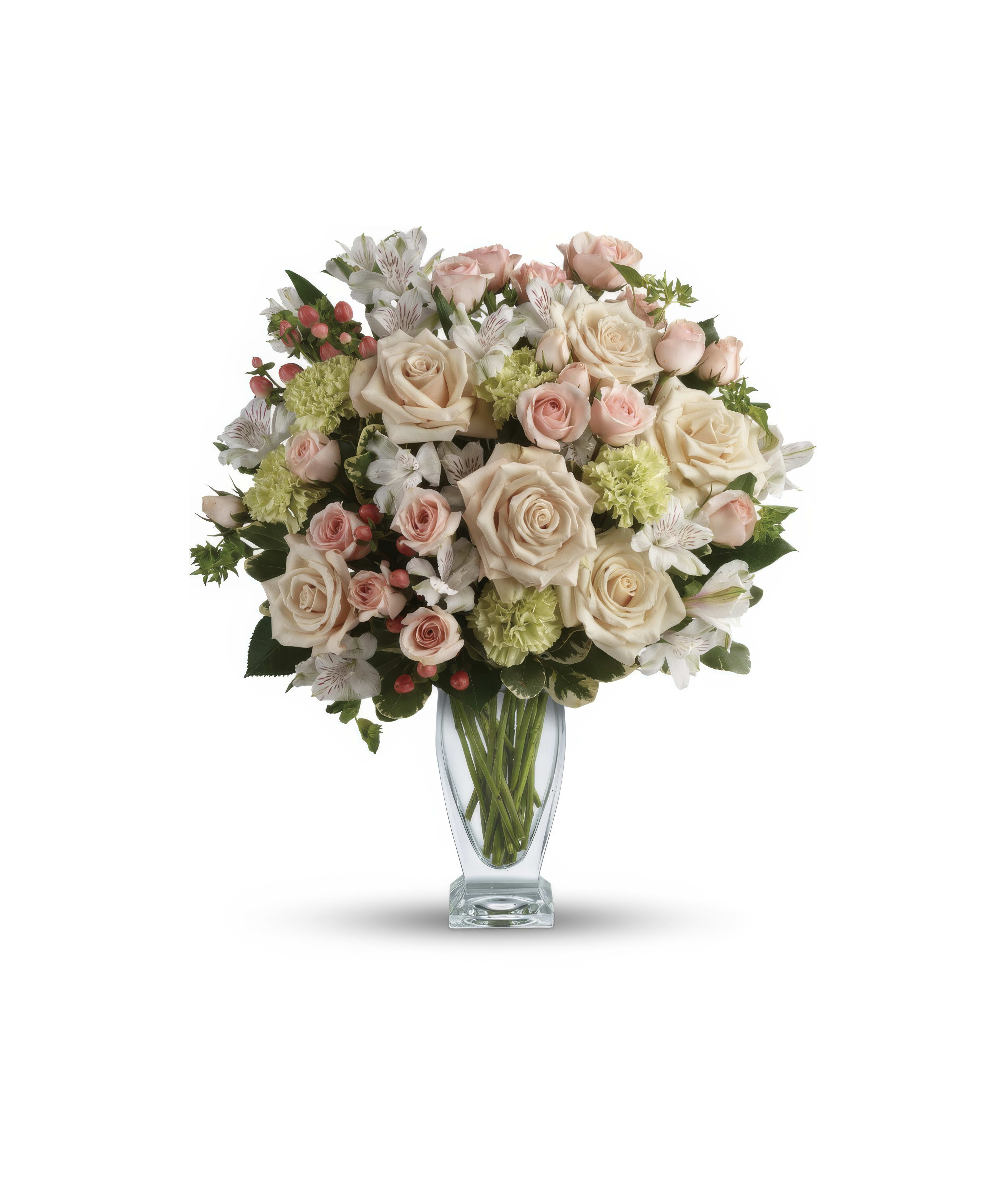 Beautiful arrangement features pink and white roses with green accents in a stylish vase.
