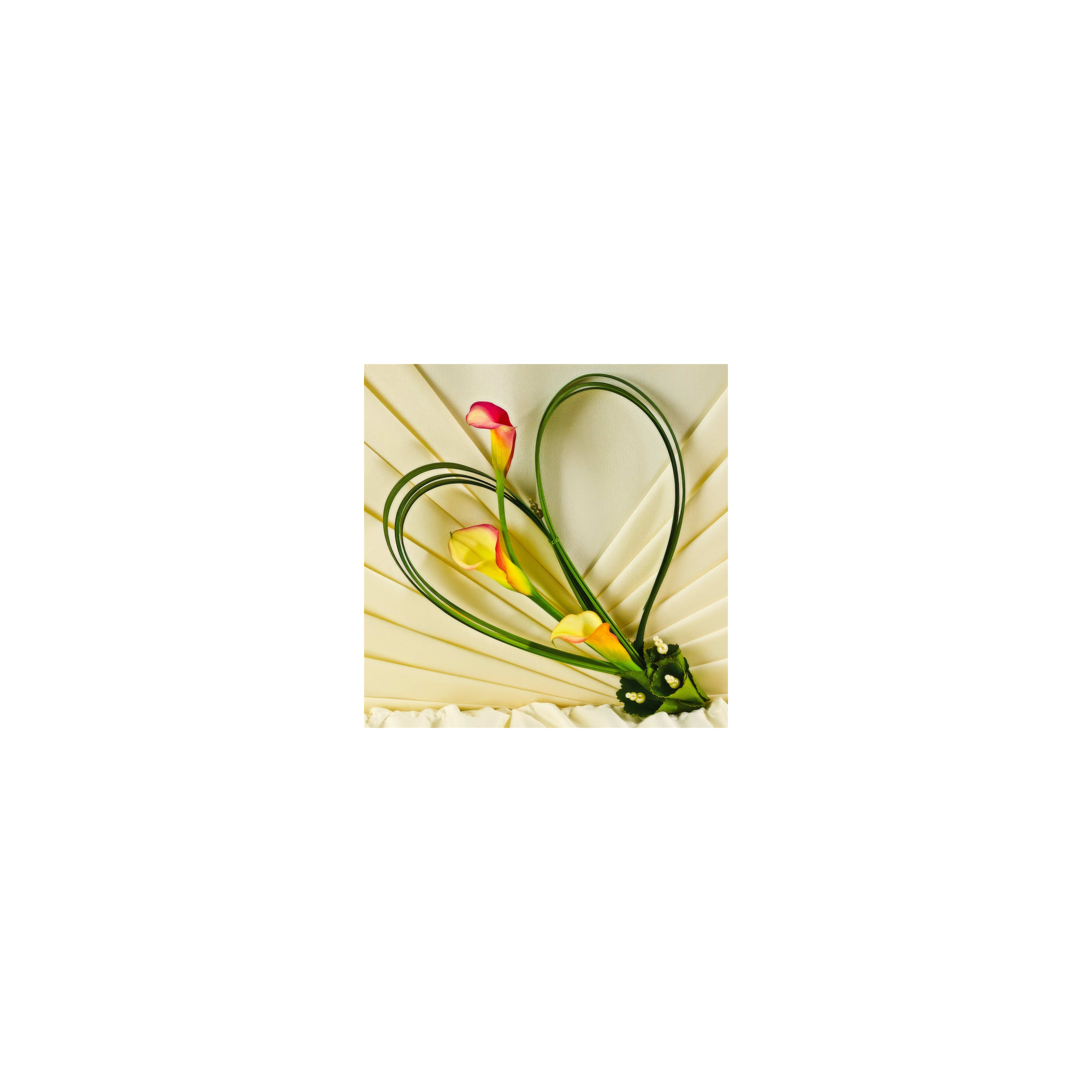 Beautiful calla lilies create a lovely heart shape on a textured fabric surface.