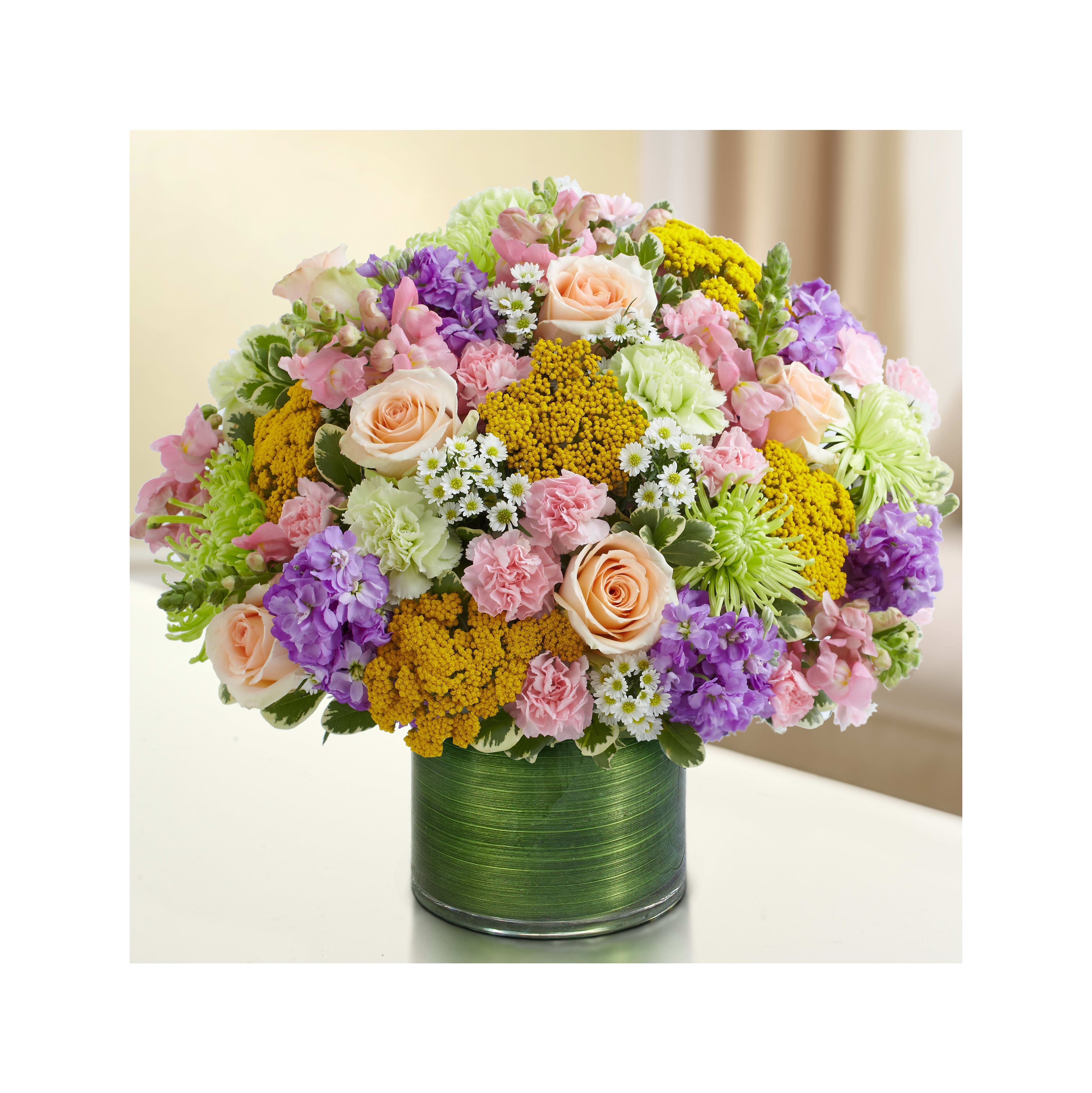 A vibrant bouquet showcasing various flowers, including roses and carnations, in a stylish vase.