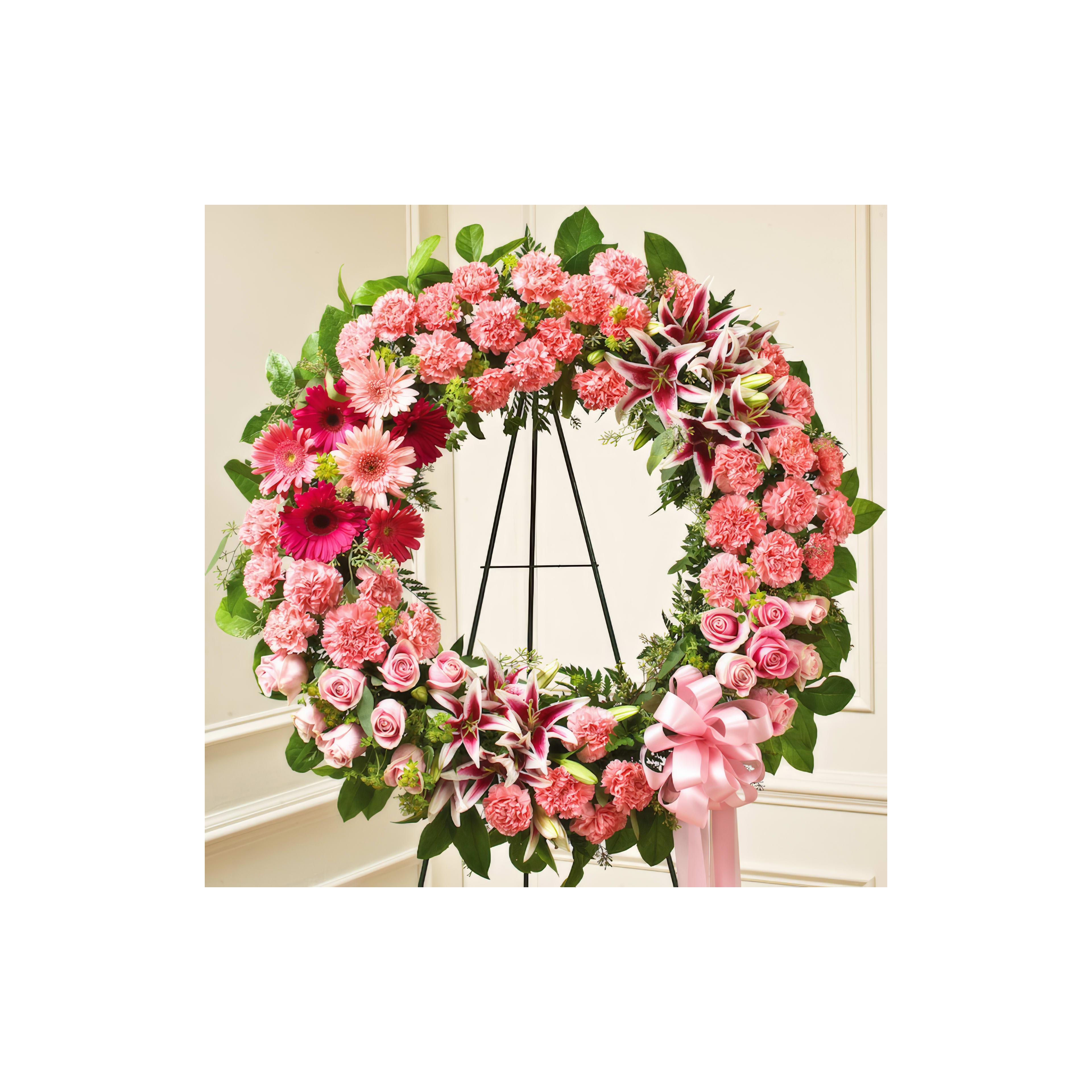 A beautifully crafted wreath made of pink flowers adorns a stand, perfect for celebrations.
