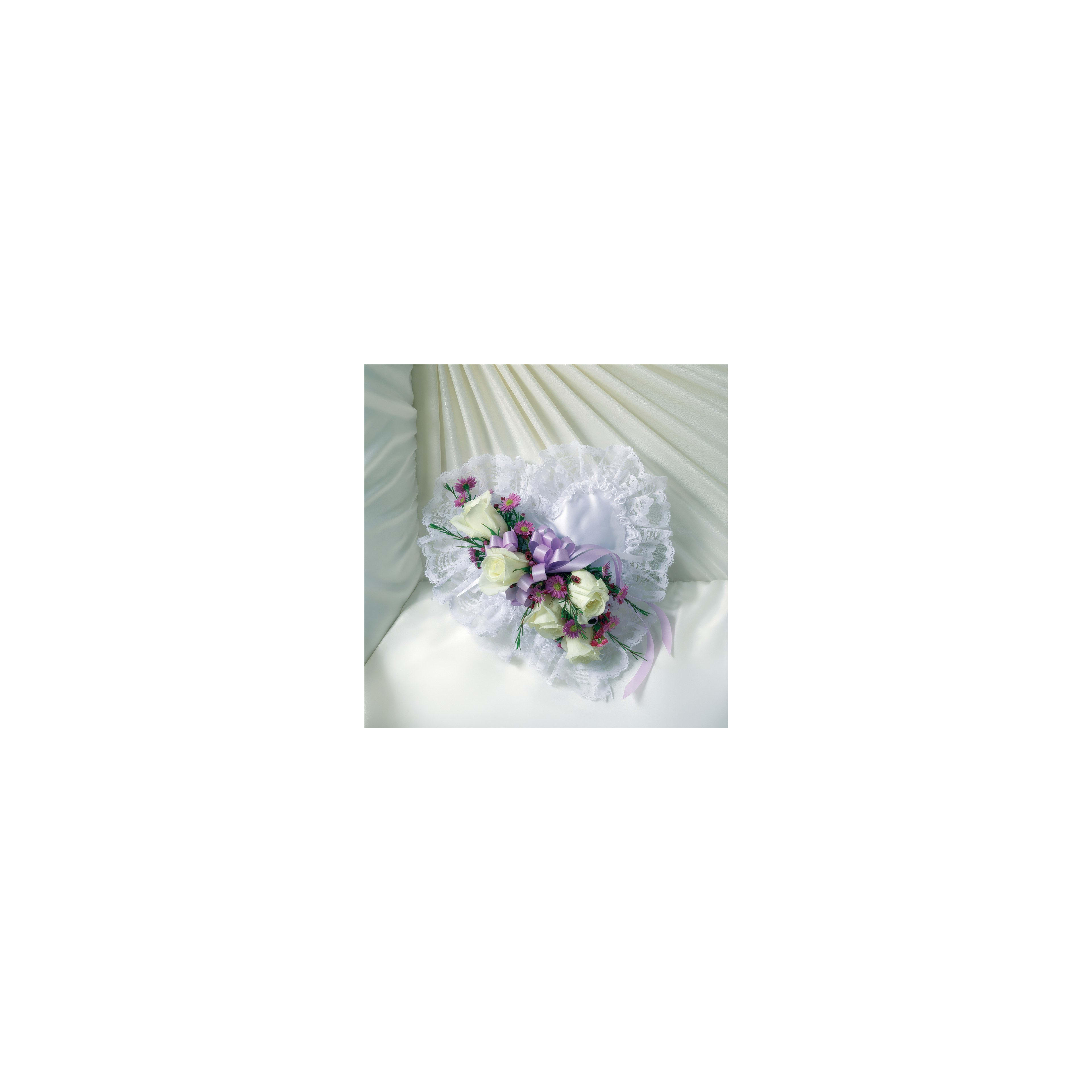 Decorative wedding bouquet featuring white roses and purple accents placed on soft white fabric.