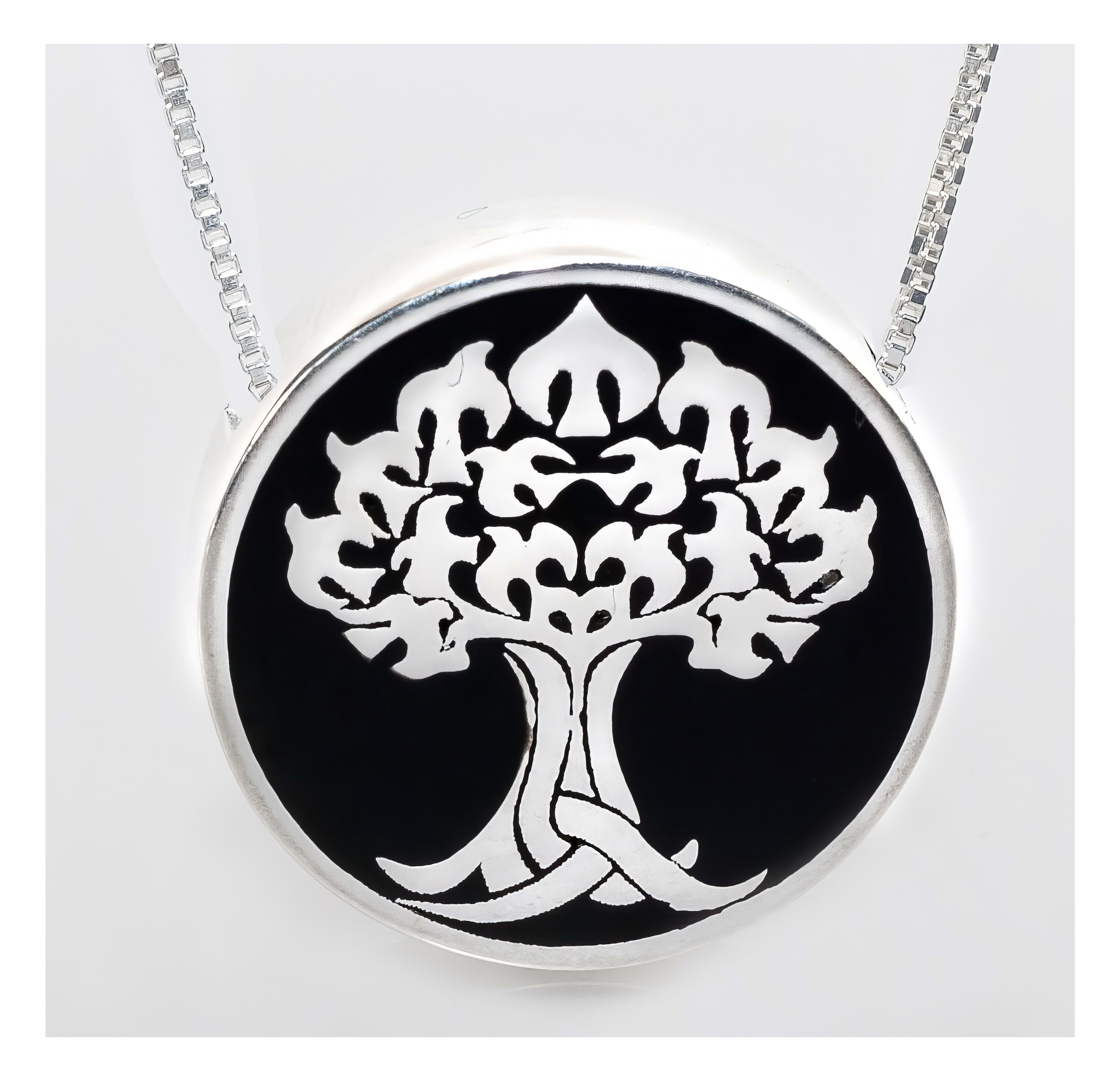Delicate silver pendant showcases an ornate tree design surrounded by a black circular backdrop.