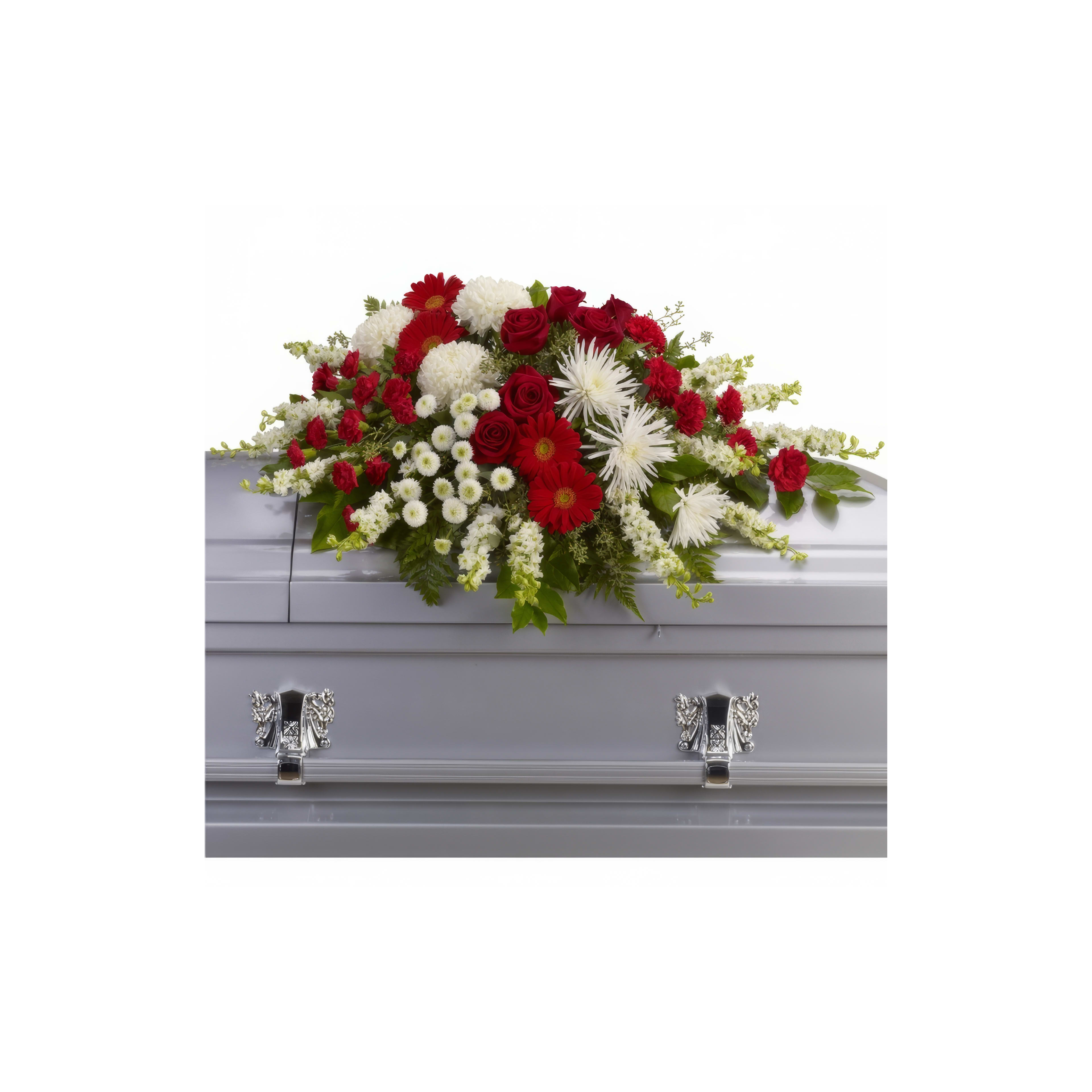 Bright red and white flowers adorn a silver casket at a memorial service, emphasizing remembrance.