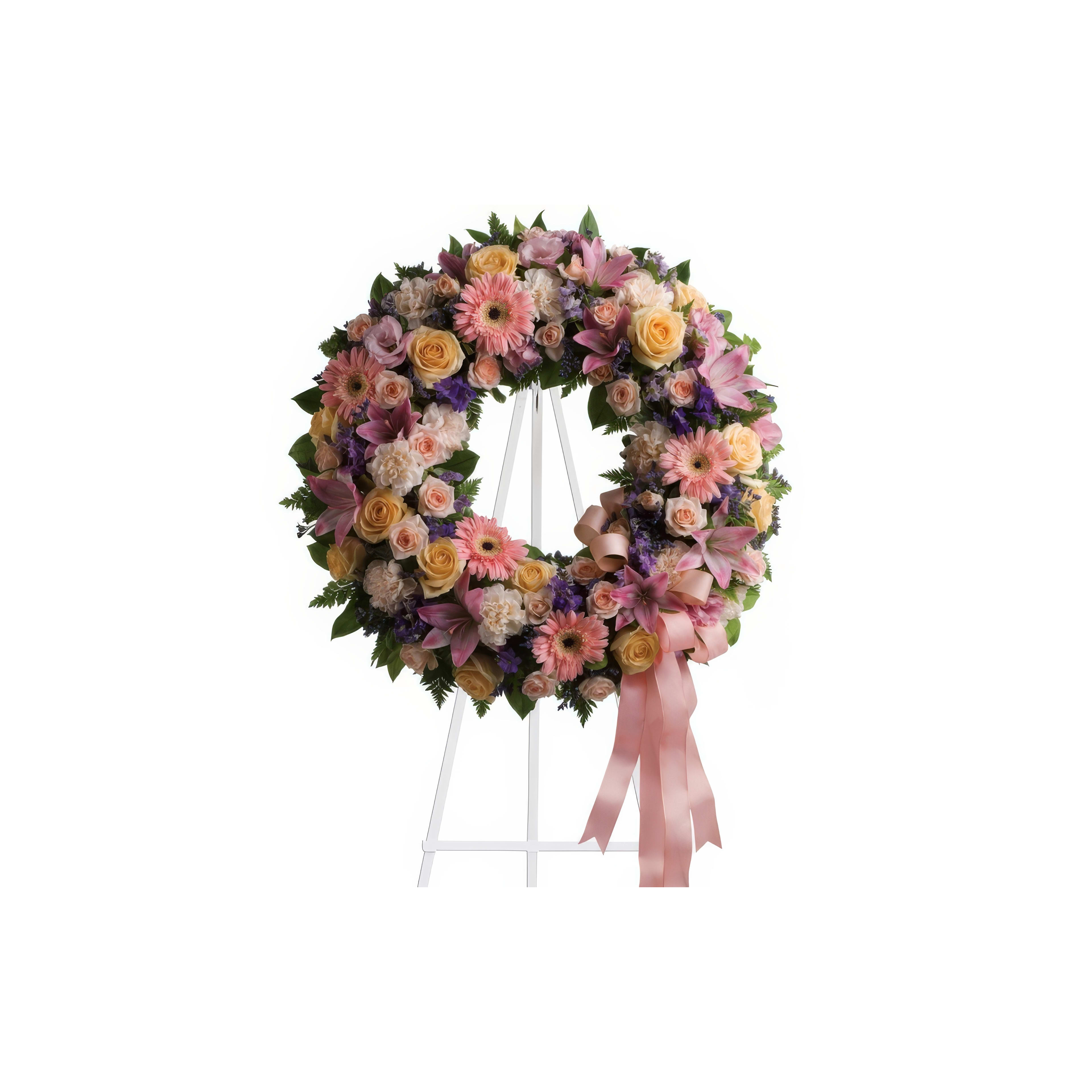 A vibrant floral wreath of roses and daisies elegantly displays in a serene setting.