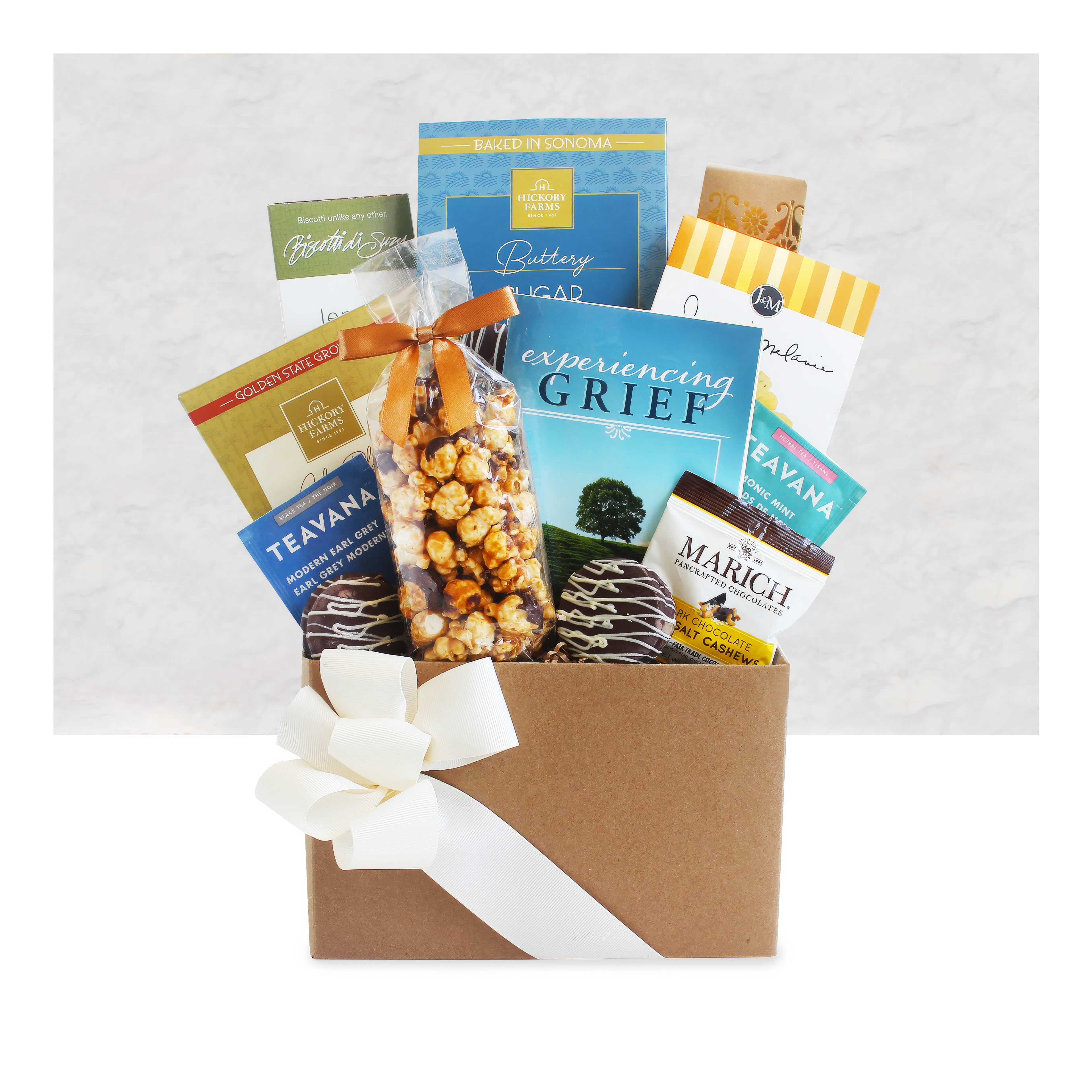 A gift box contains various teas, sweet snacks, and uplifting books to provide comfort and support.