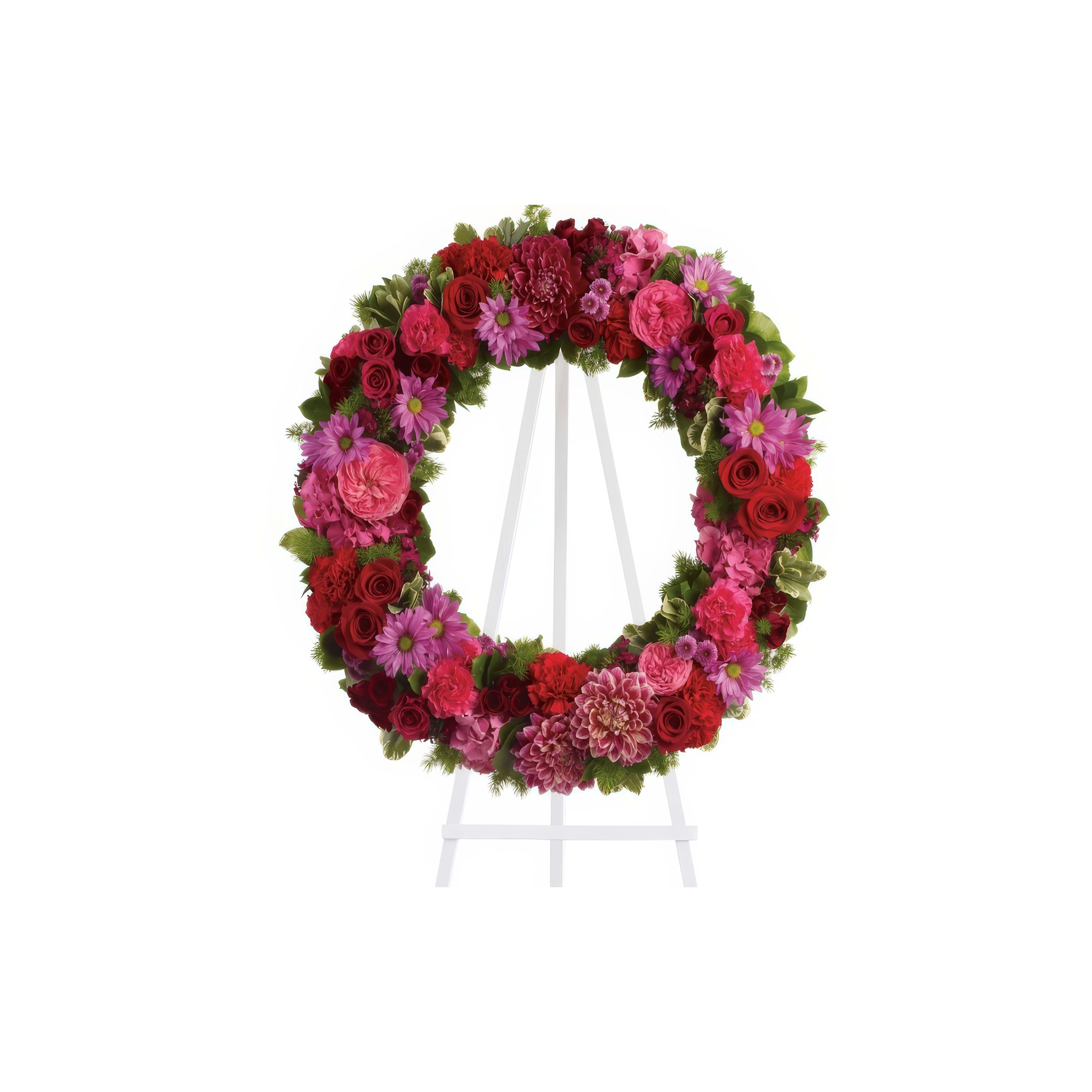 A colorful floral wreath made of various flowers is featured prominently on an easel.