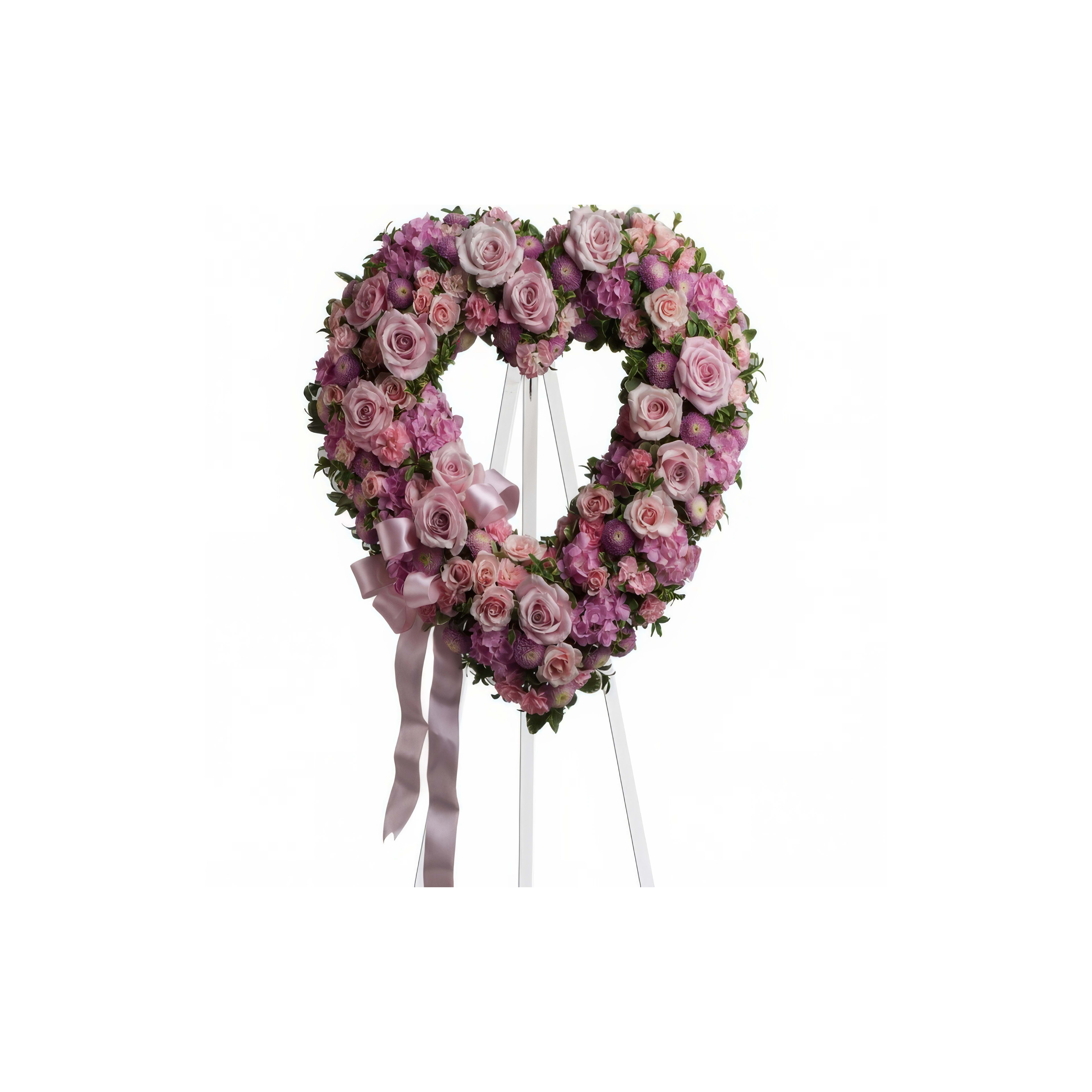 A beautiful heart-shaped arrangement of pink roses displayed on a stand, perfect for tributes.