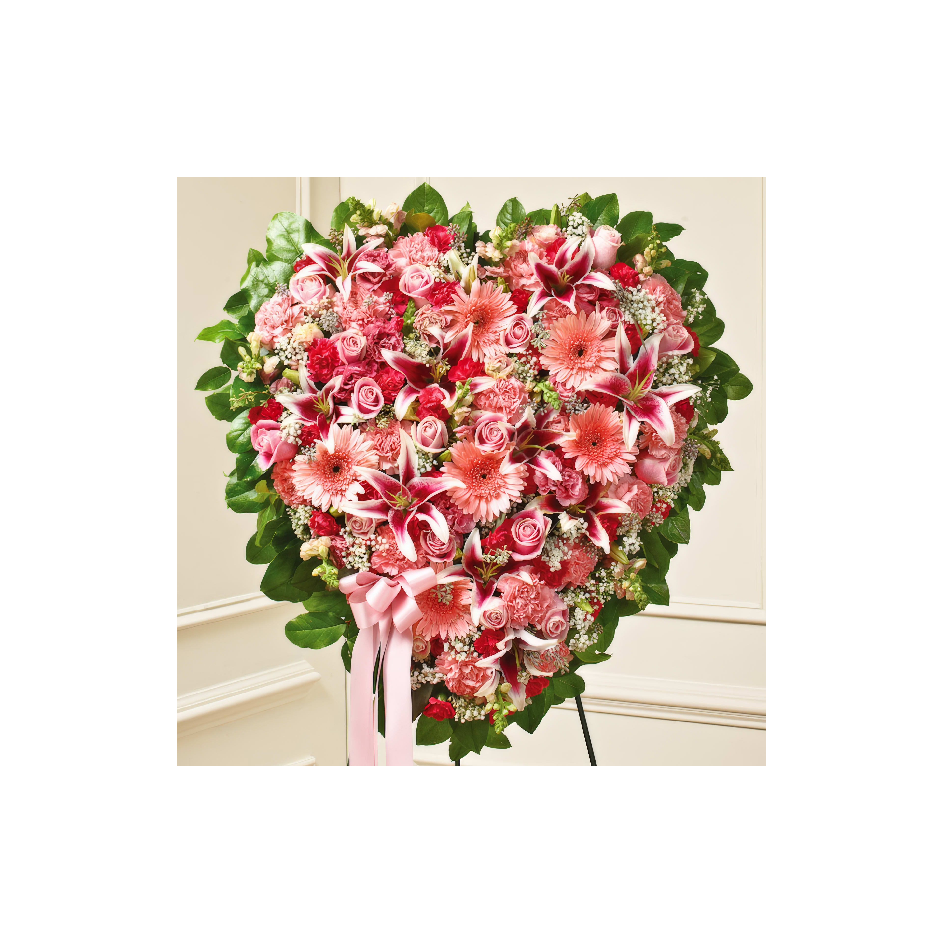 This lovely heart-shaped flower display features pink roses and lilies, perfect for celebrations.
