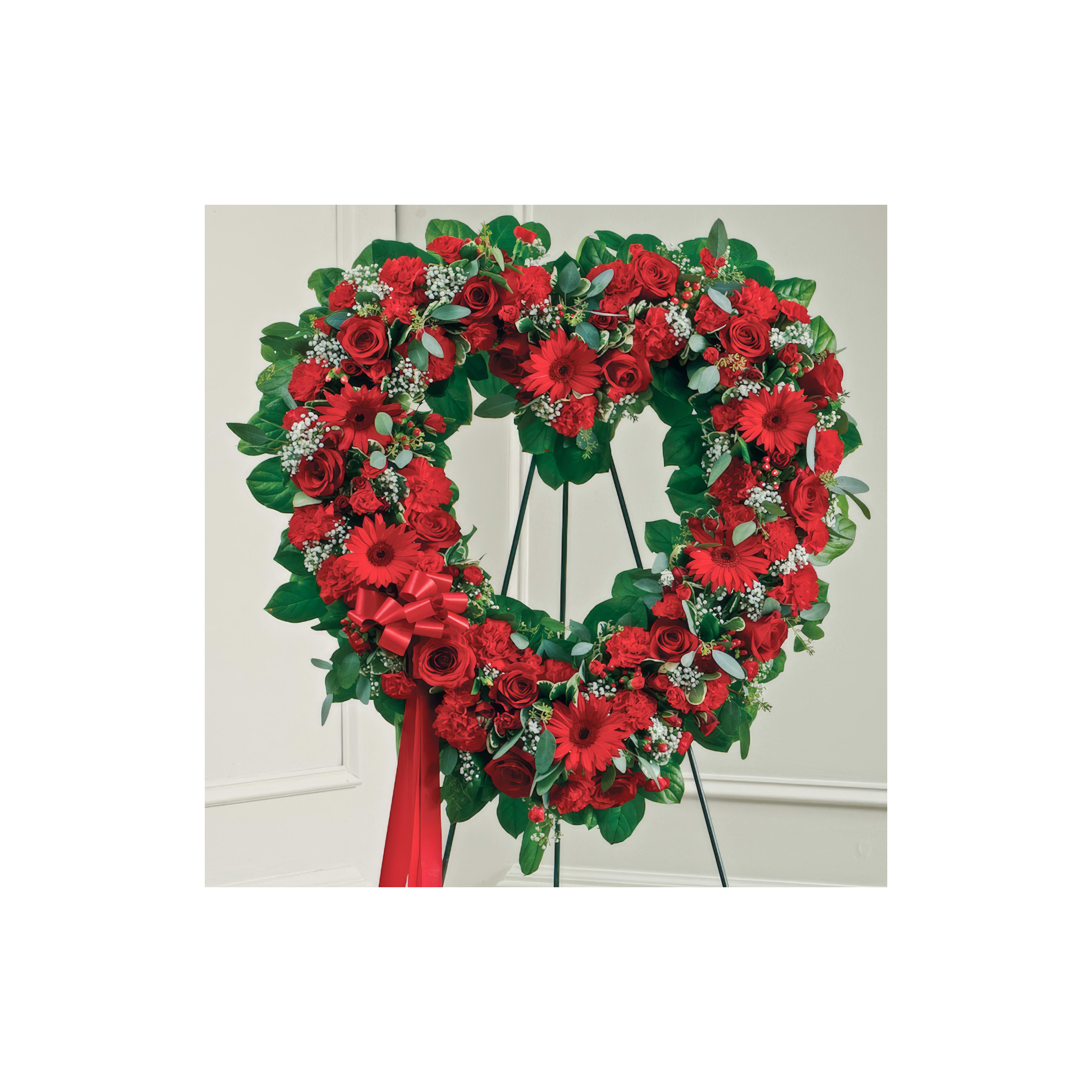 A heart-shaped floral arrangement of red roses and greenery showcases exquisite craftsmanship.