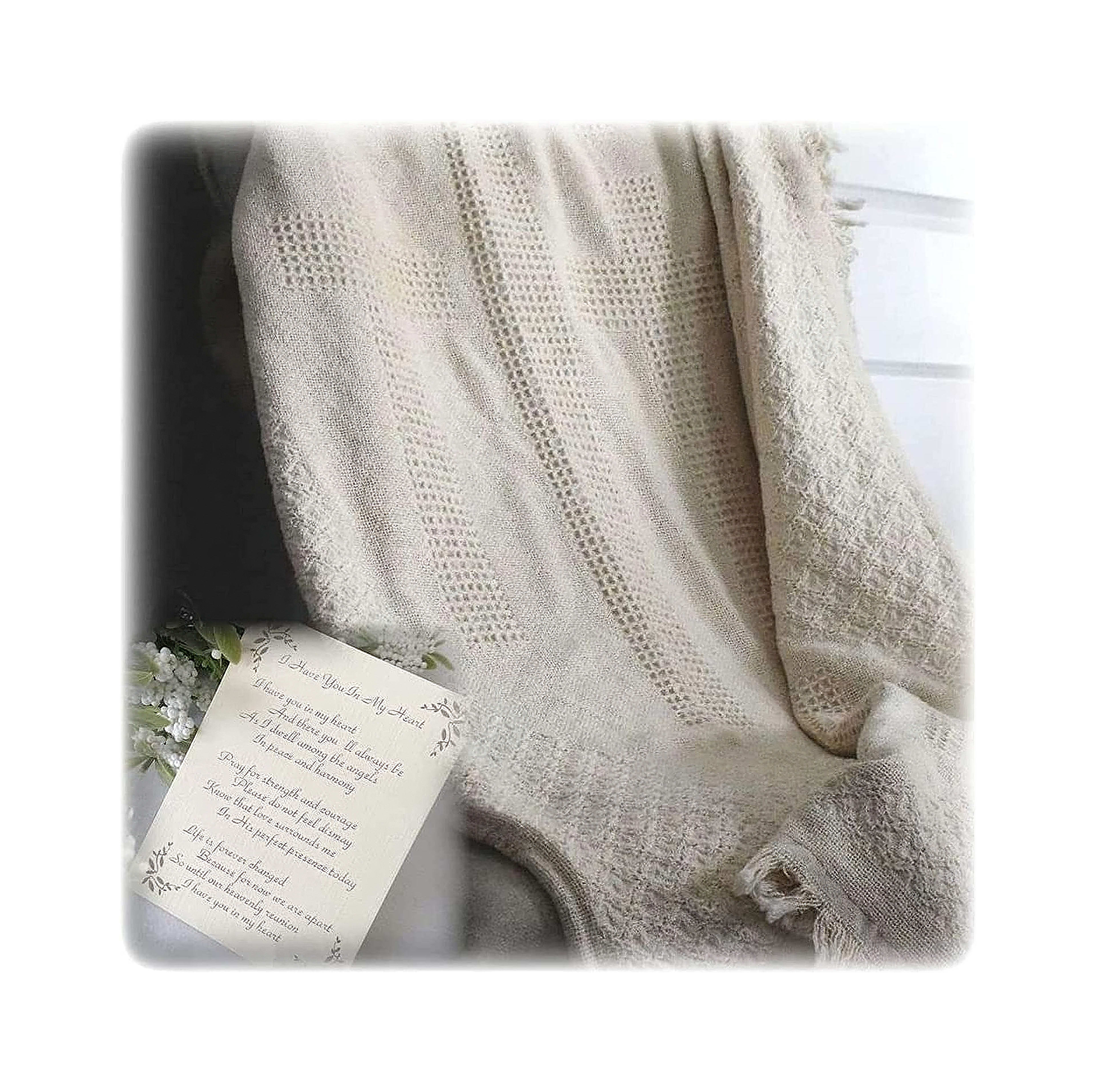 A soft cream blanket rests on a chair beside an elegant handwritten letter on a table.