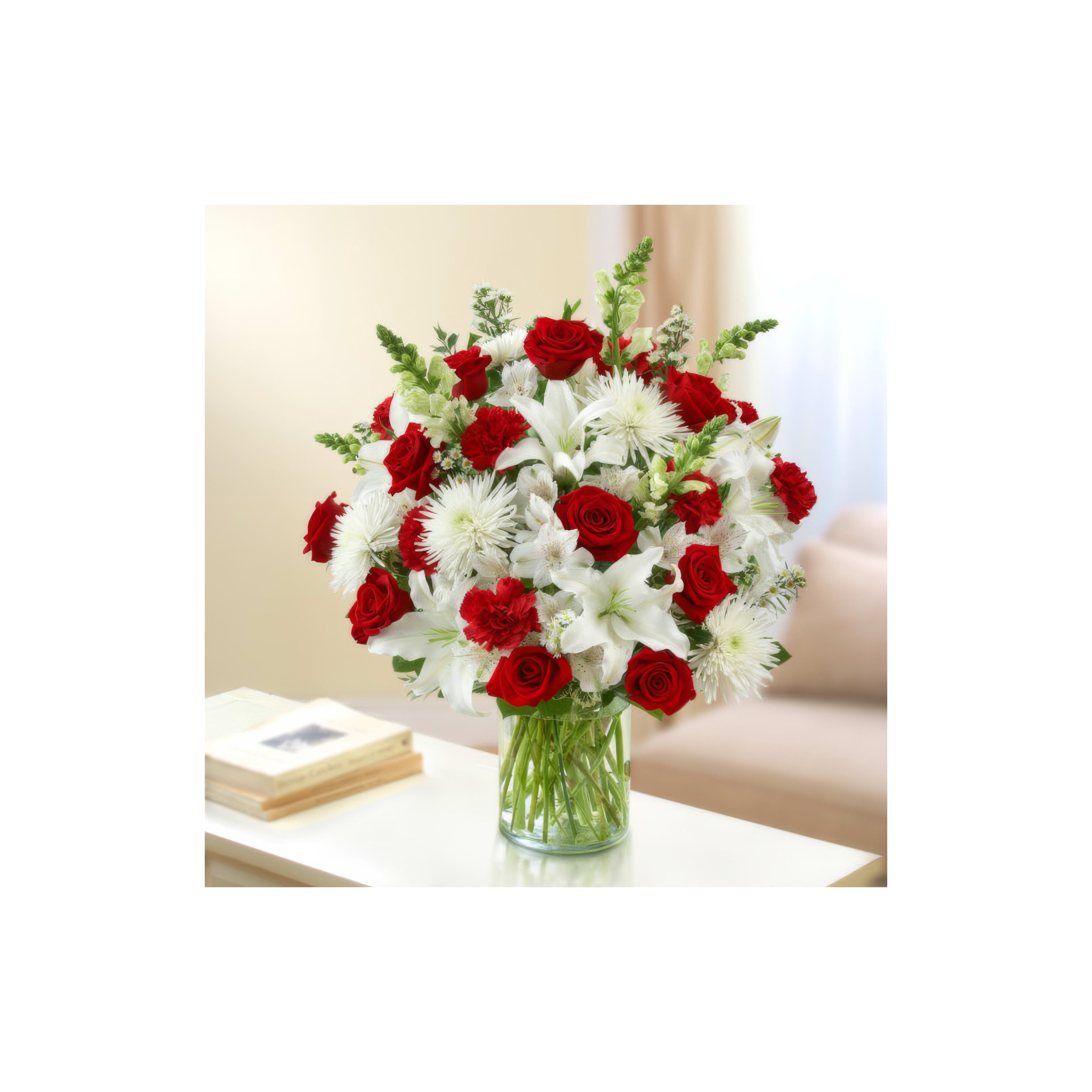 A beautiful bouquet of red roses and white lilies stands elegantly in a glass vase.