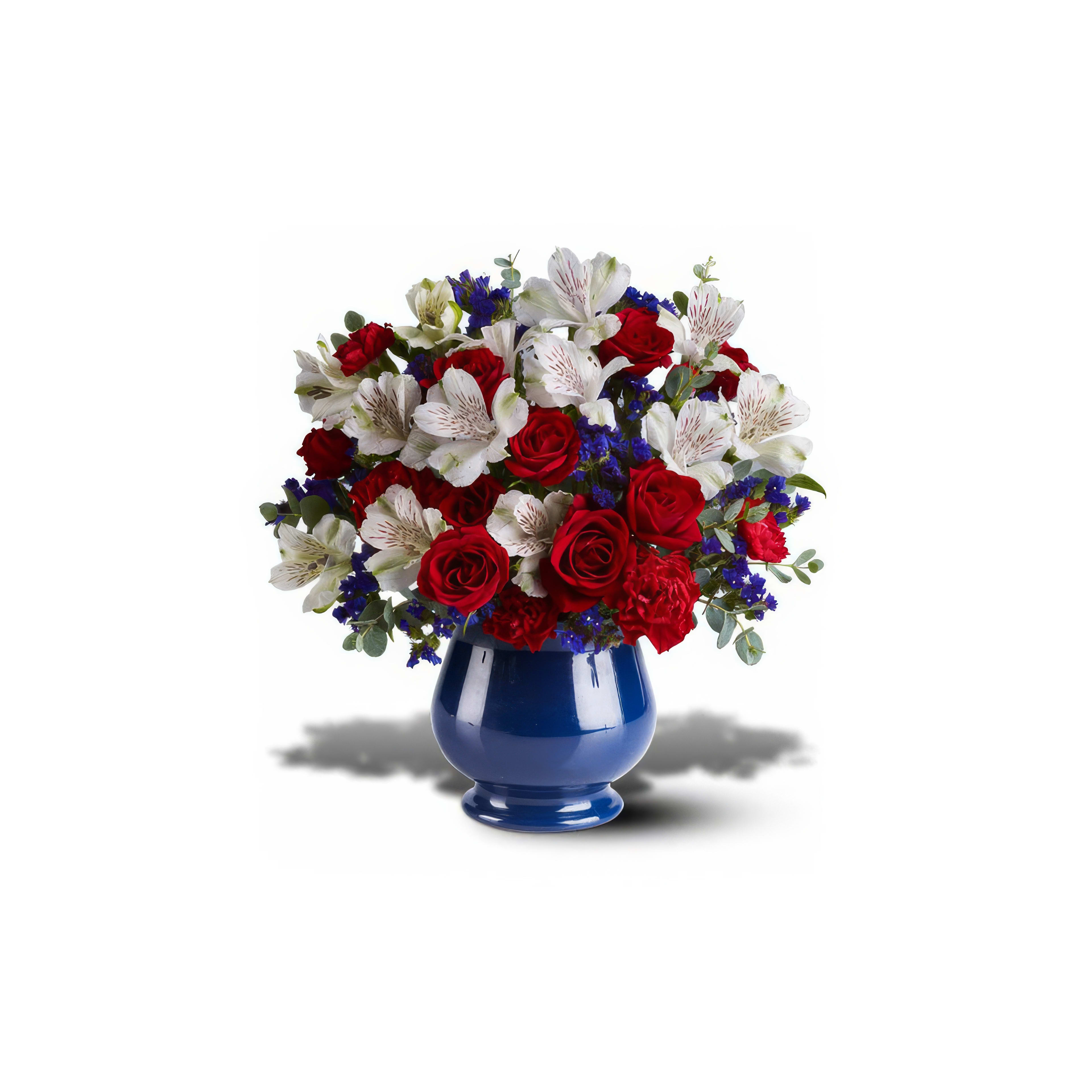 Colorful bouquet featuring red roses, white lilies, and blue flowers in a decorative vase.