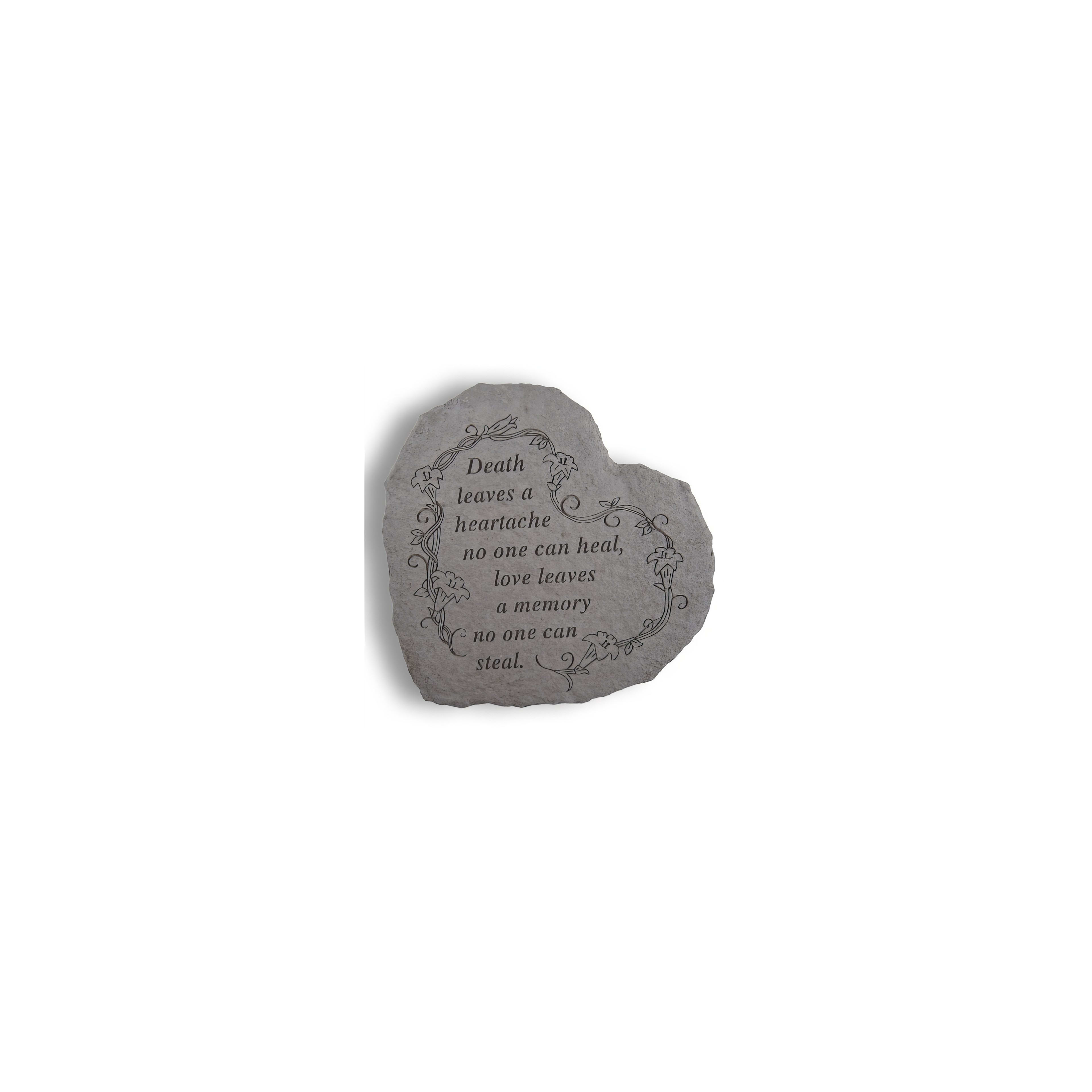 Engraved stone with heartfelt words about love and loss sits quietly in a serene garden area.