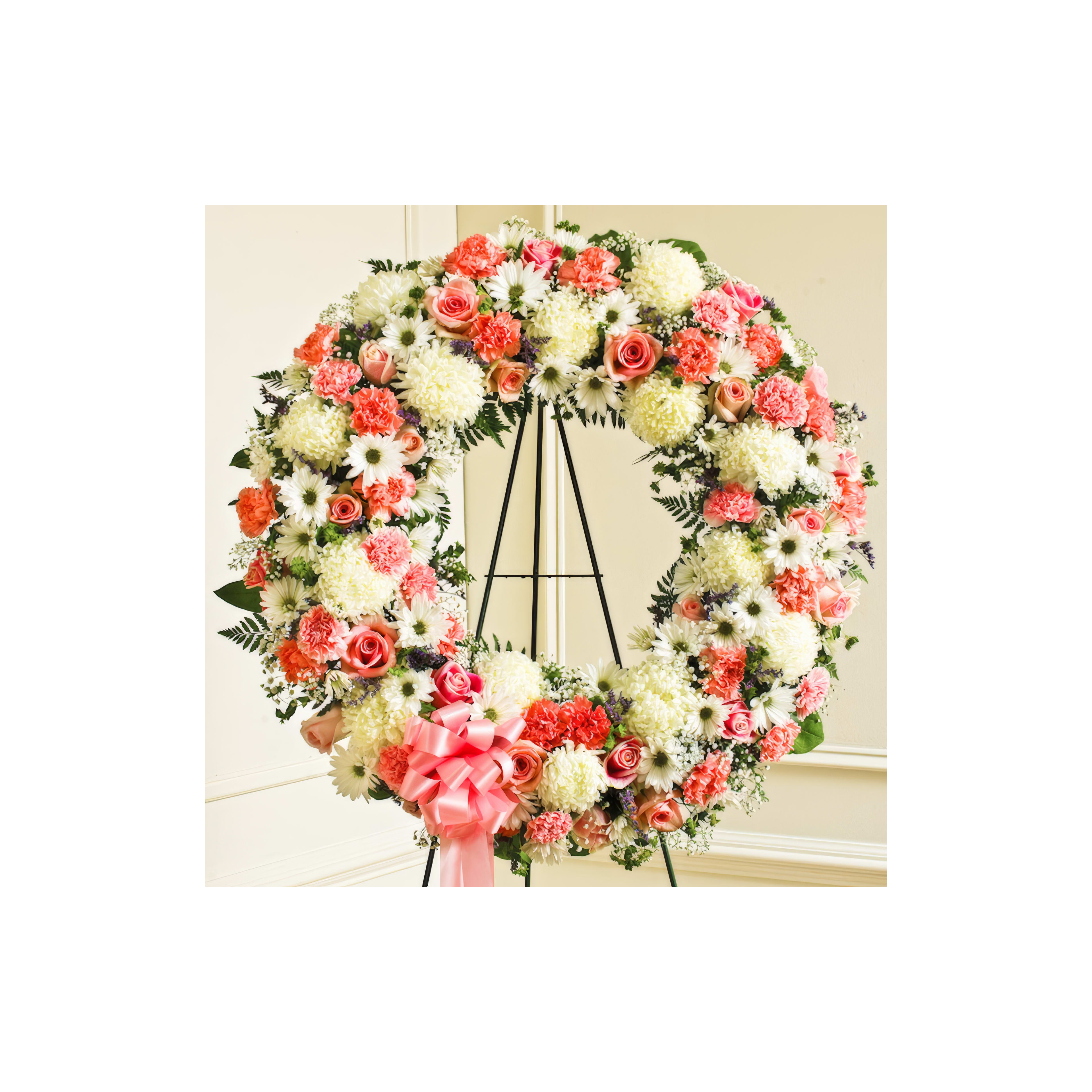 A circular floral arrangement showcases white and coral flowers, symbolizing remembrance and love.