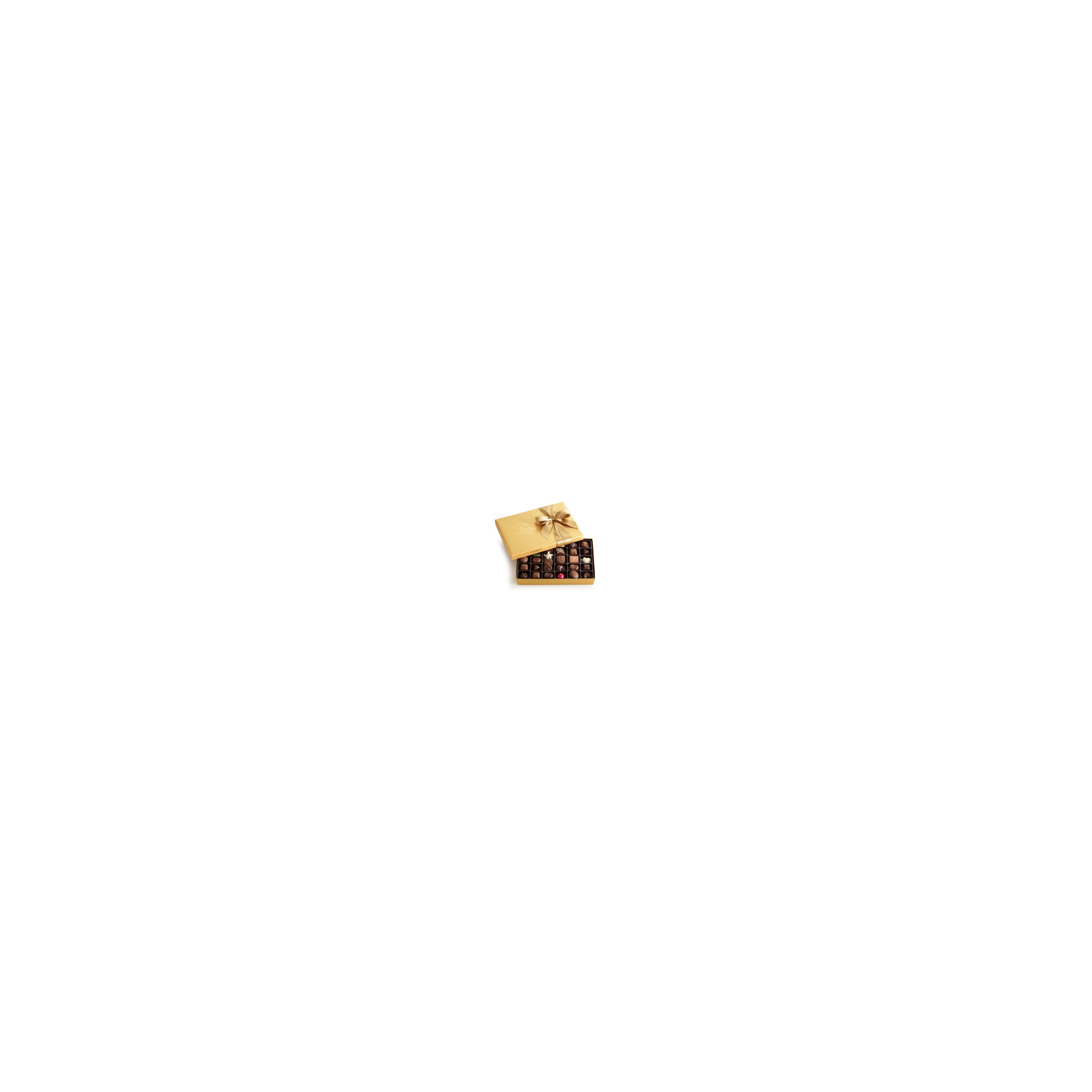 A beautiful selection of chocolates neatly arranged in an elegant golden box with a ribbon.