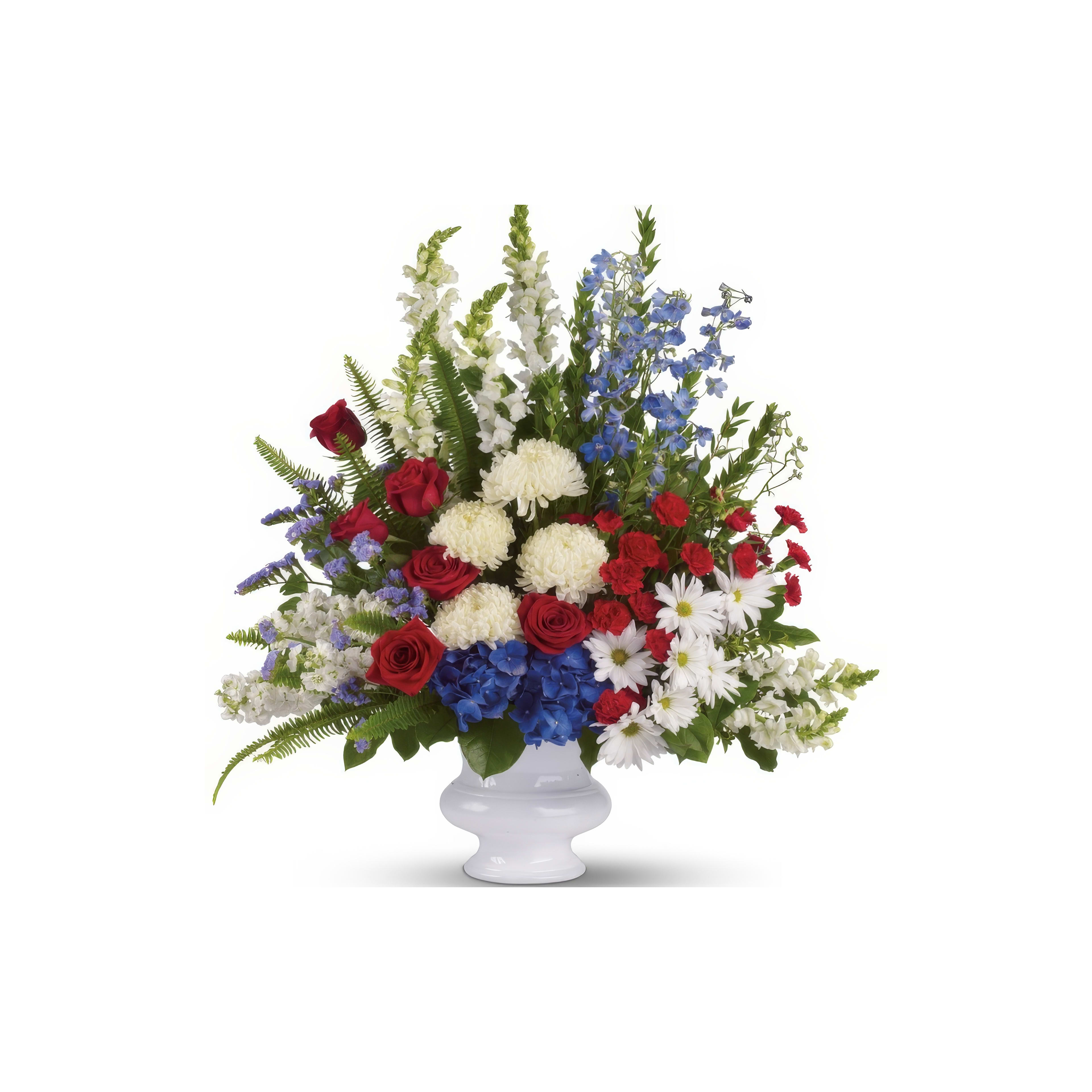 A bright mix of red, white, and blue roses and daisies fills a white vase.