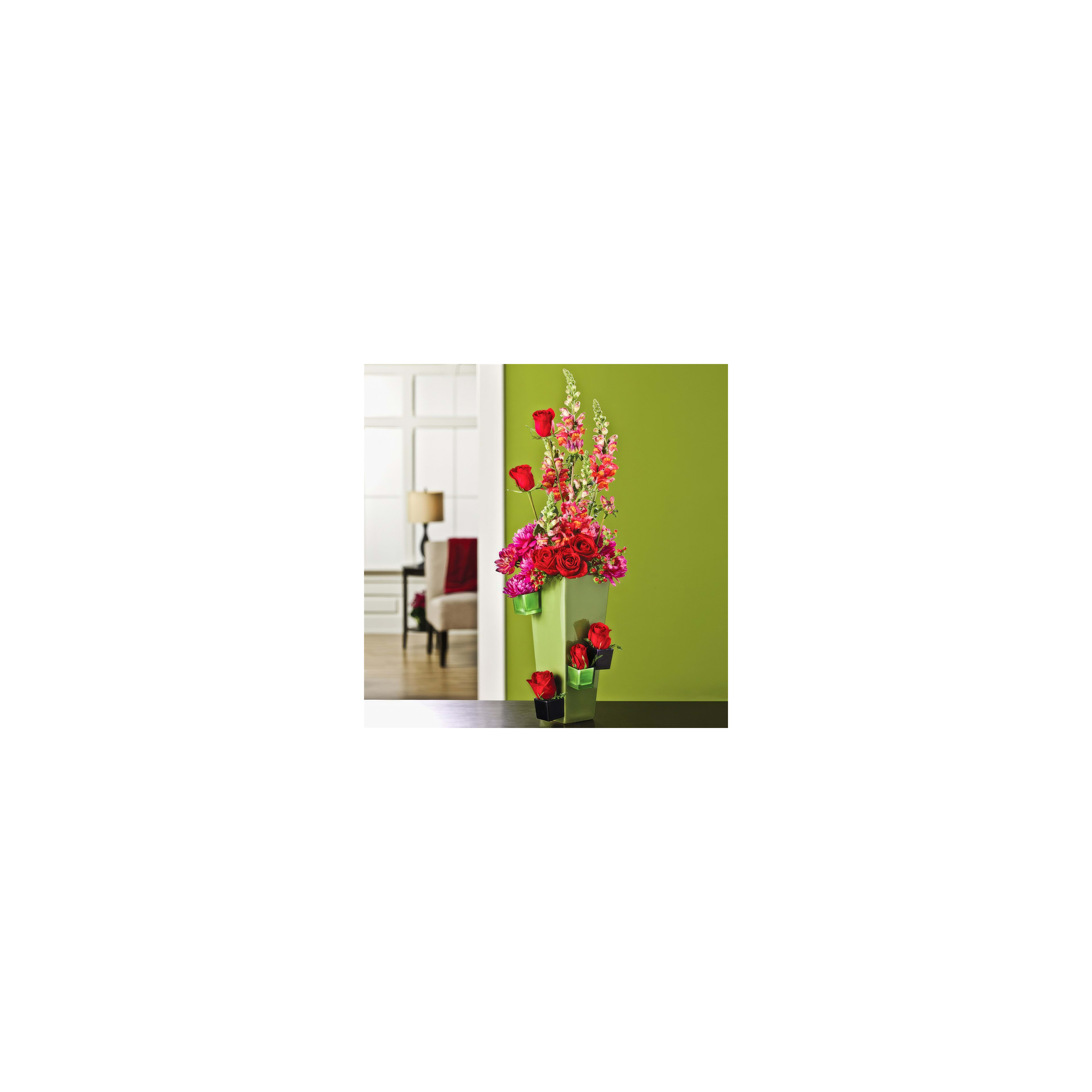A vibrant collection of flowers stands elegantly in a green vase, brightening the room.