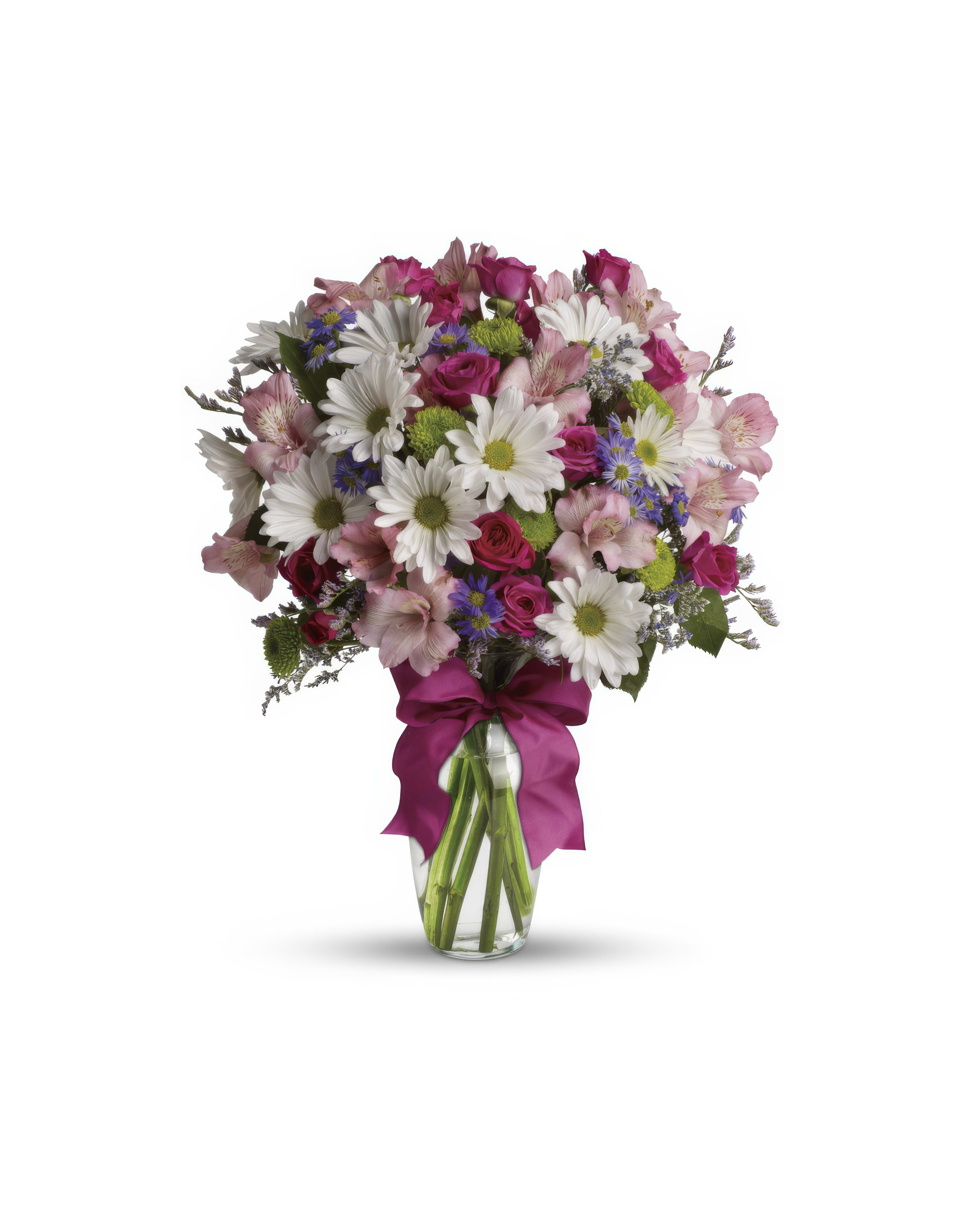 A vibrant arrangement of daisies, roses, and other flowers presented in a clear vase.