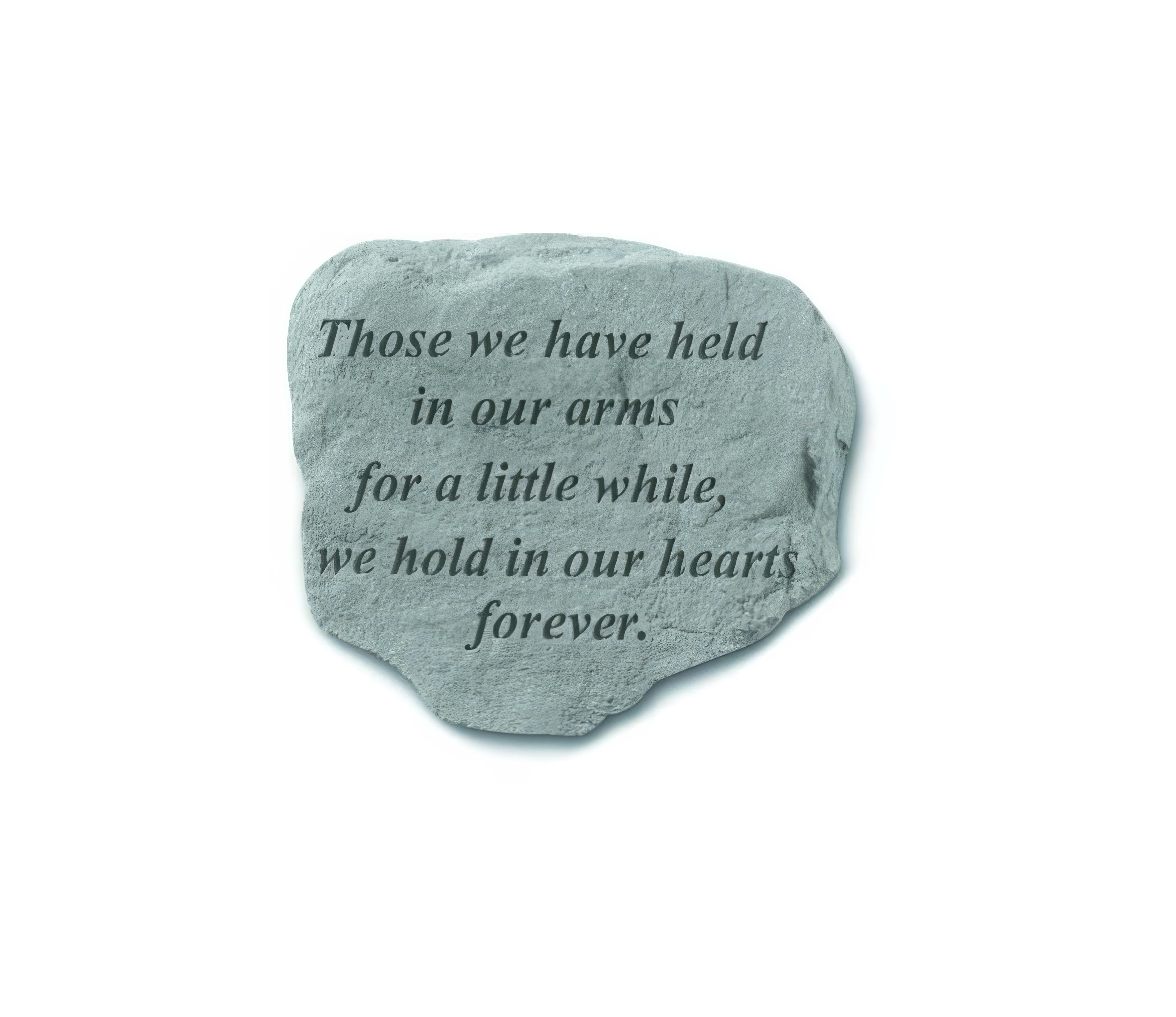 A stone with an engraved message about love and memory is placed in a quiet garden.