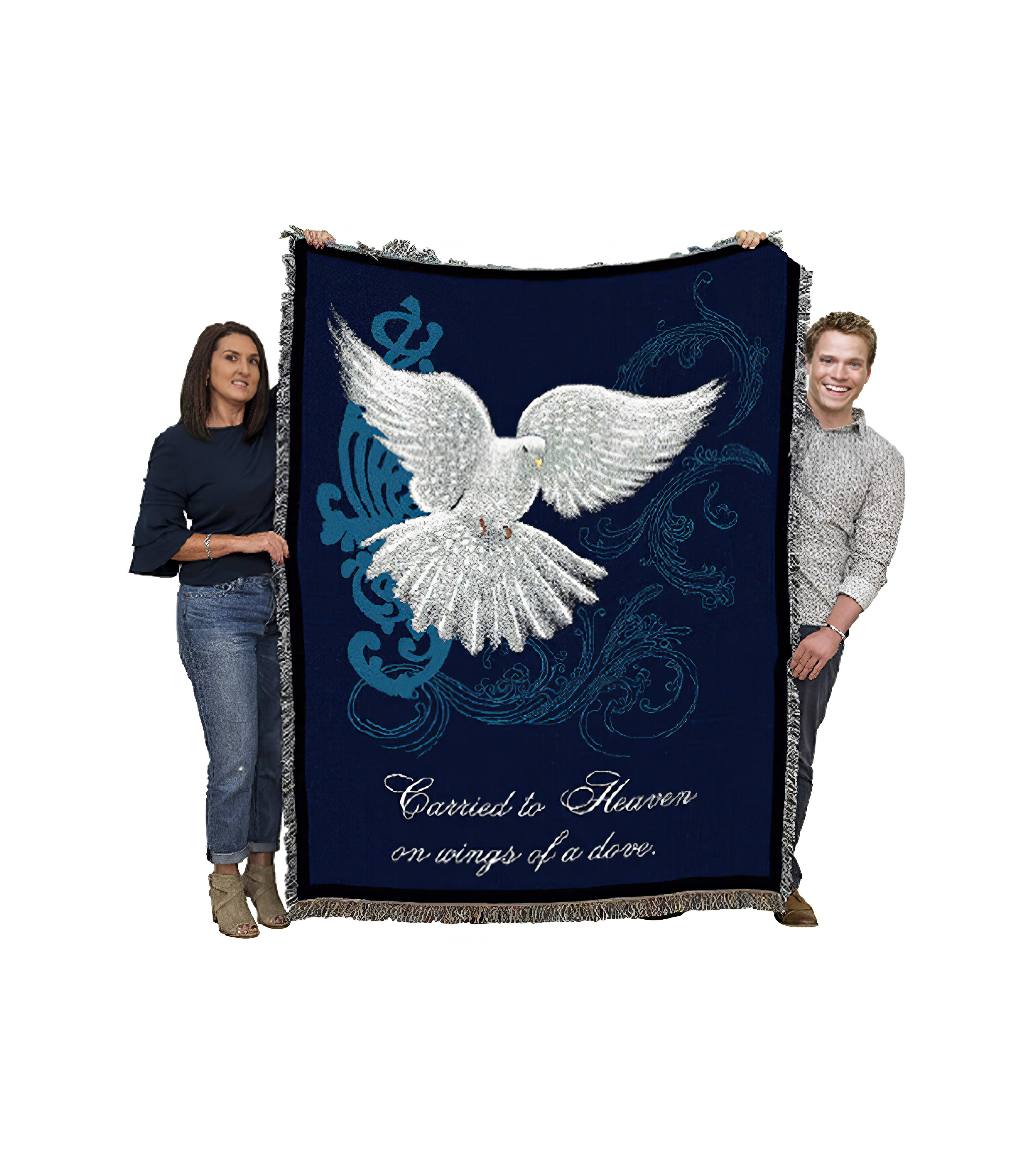 Individuals display a large blanket adorned with a dove design and uplifting message indoors.