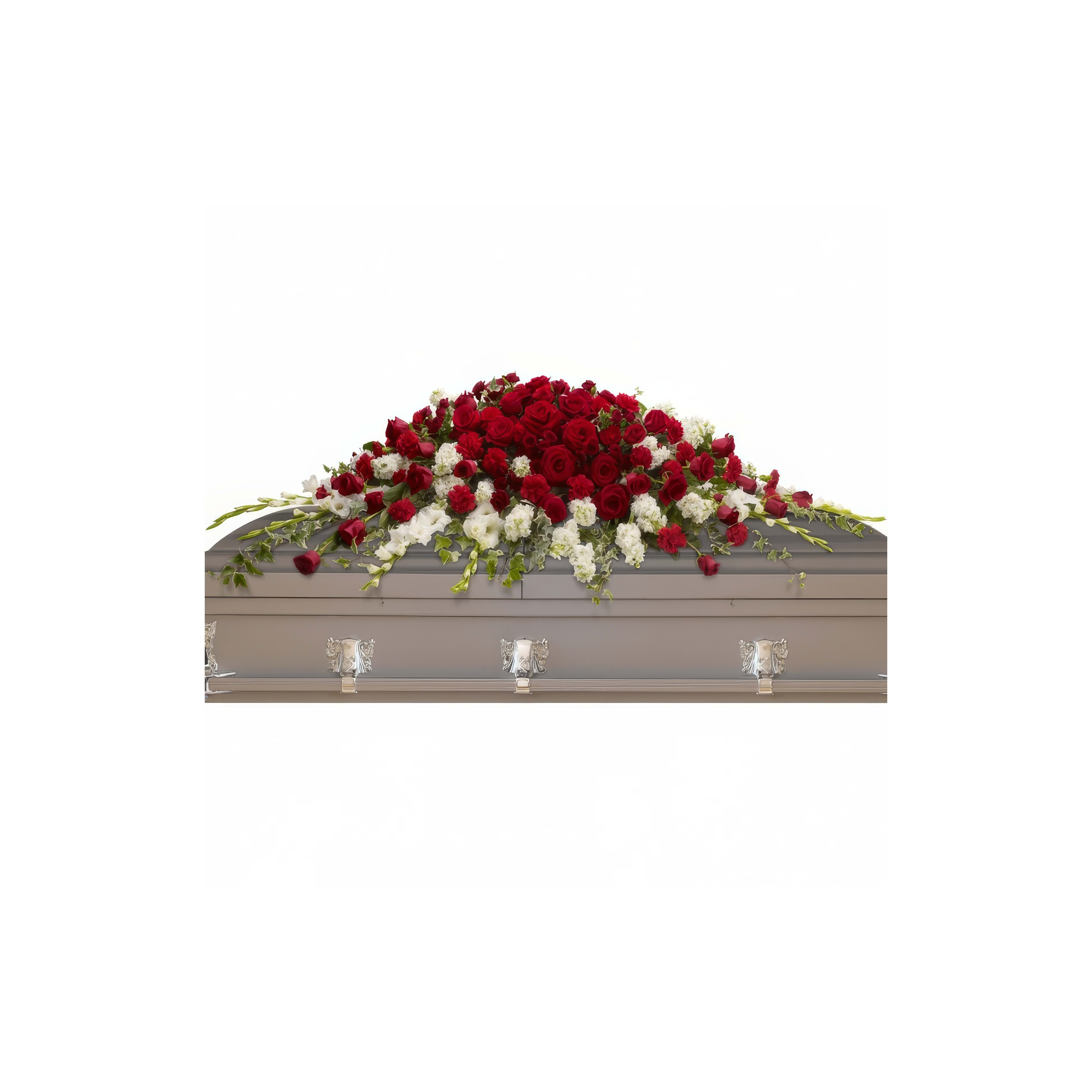 Red and white flowers on a casket symbolize love and remembrance in a serene setting.