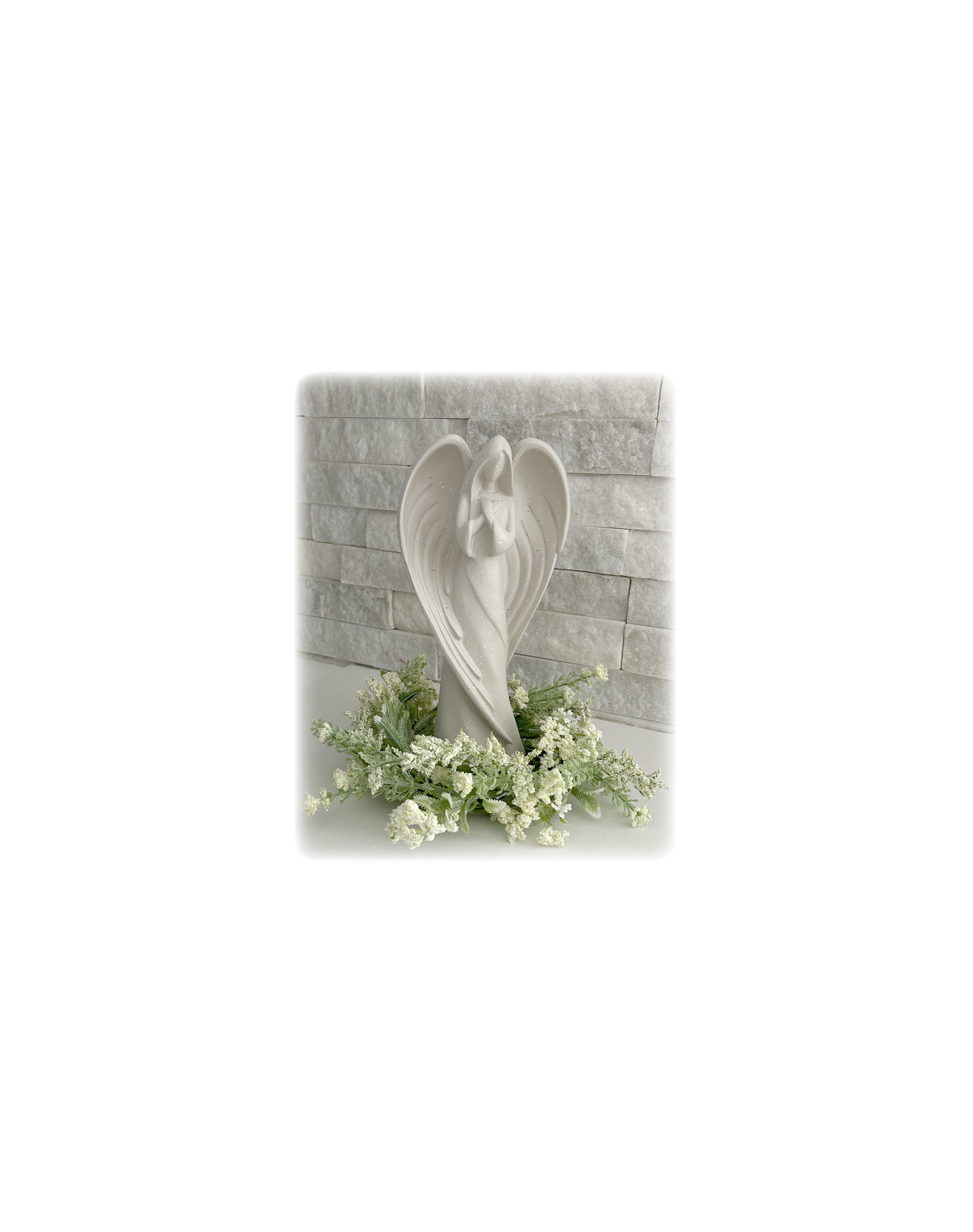 A graceful angel in the center adorned with delicate white flowers enhances the décor.