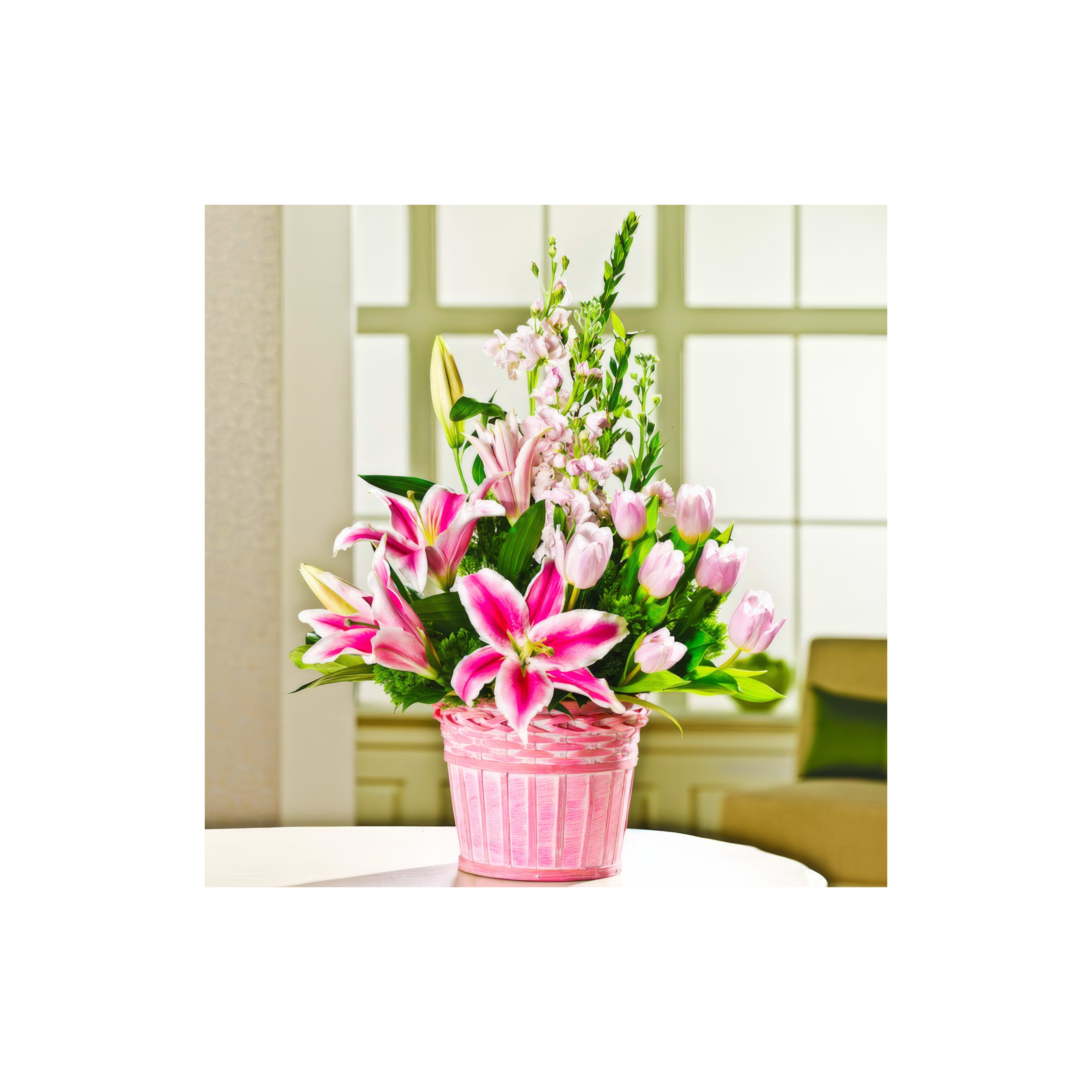 A vibrant arrangement of pink lilies and tulips in a stylish pot enhances the indoor atmosphere.