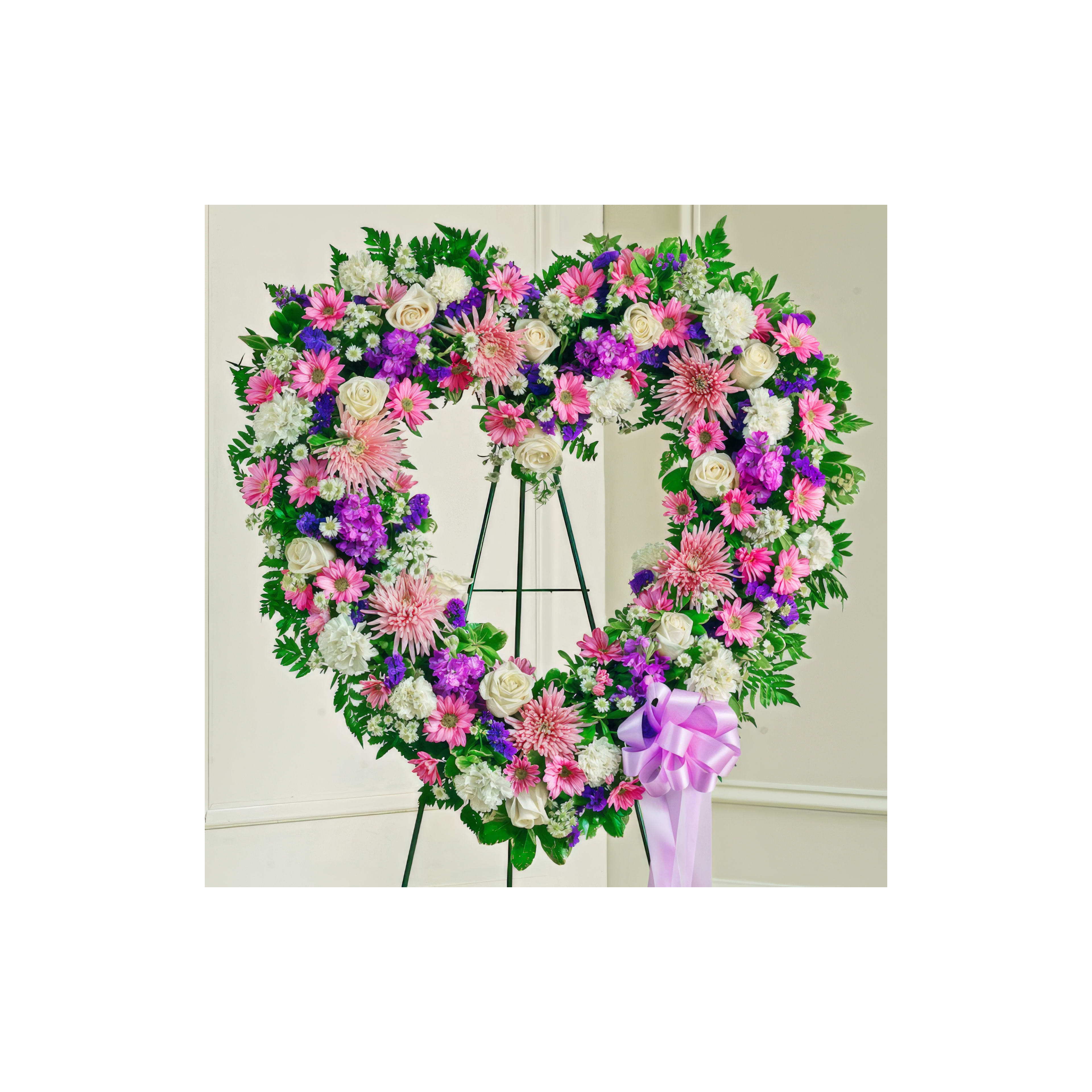 Heart-shaped floral tribute with pink, purple, and white blooms symbolizes love and remembrance.