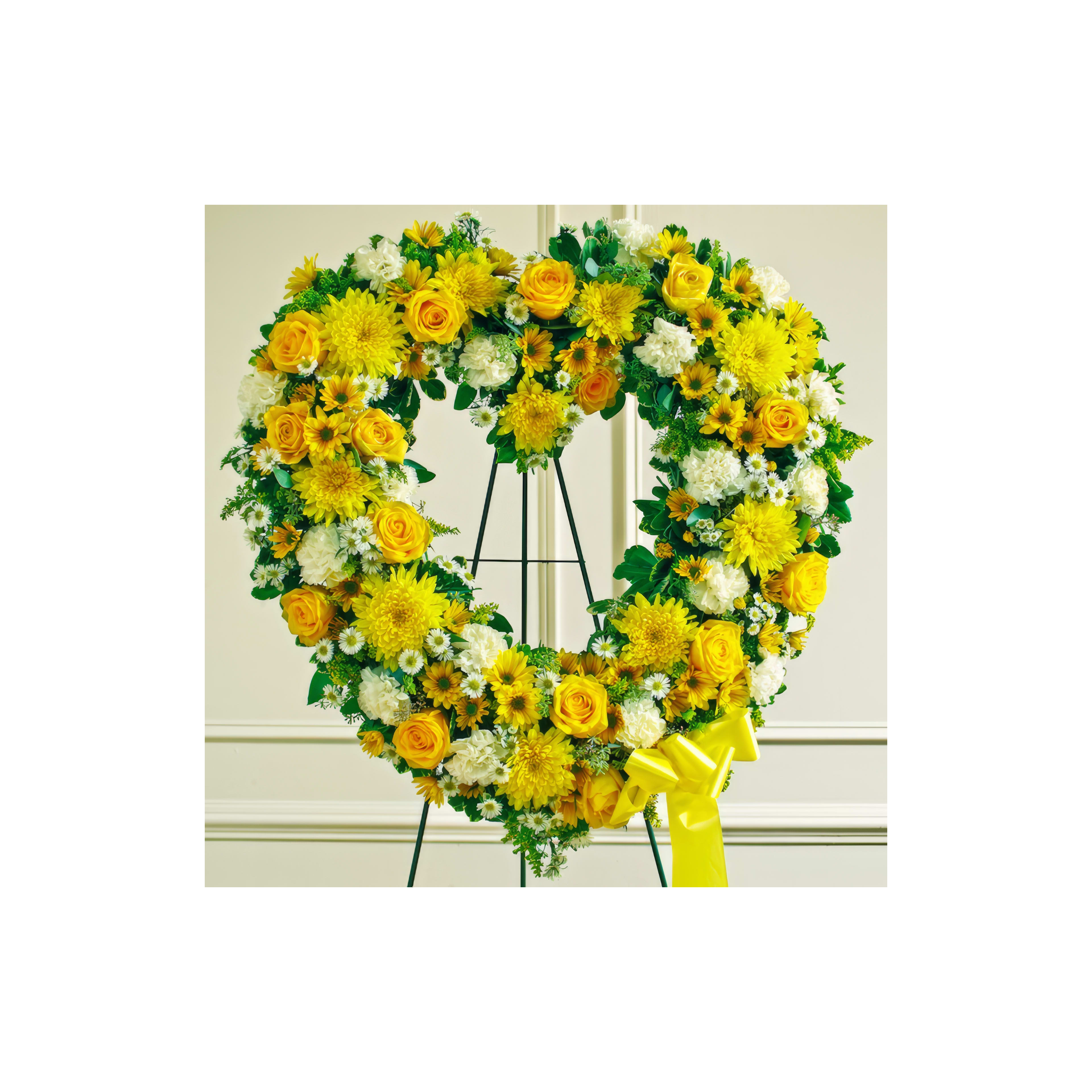 A stunning heart-shaped wreath made of yellow roses, sunflowers, and white blooms stands elegantly.