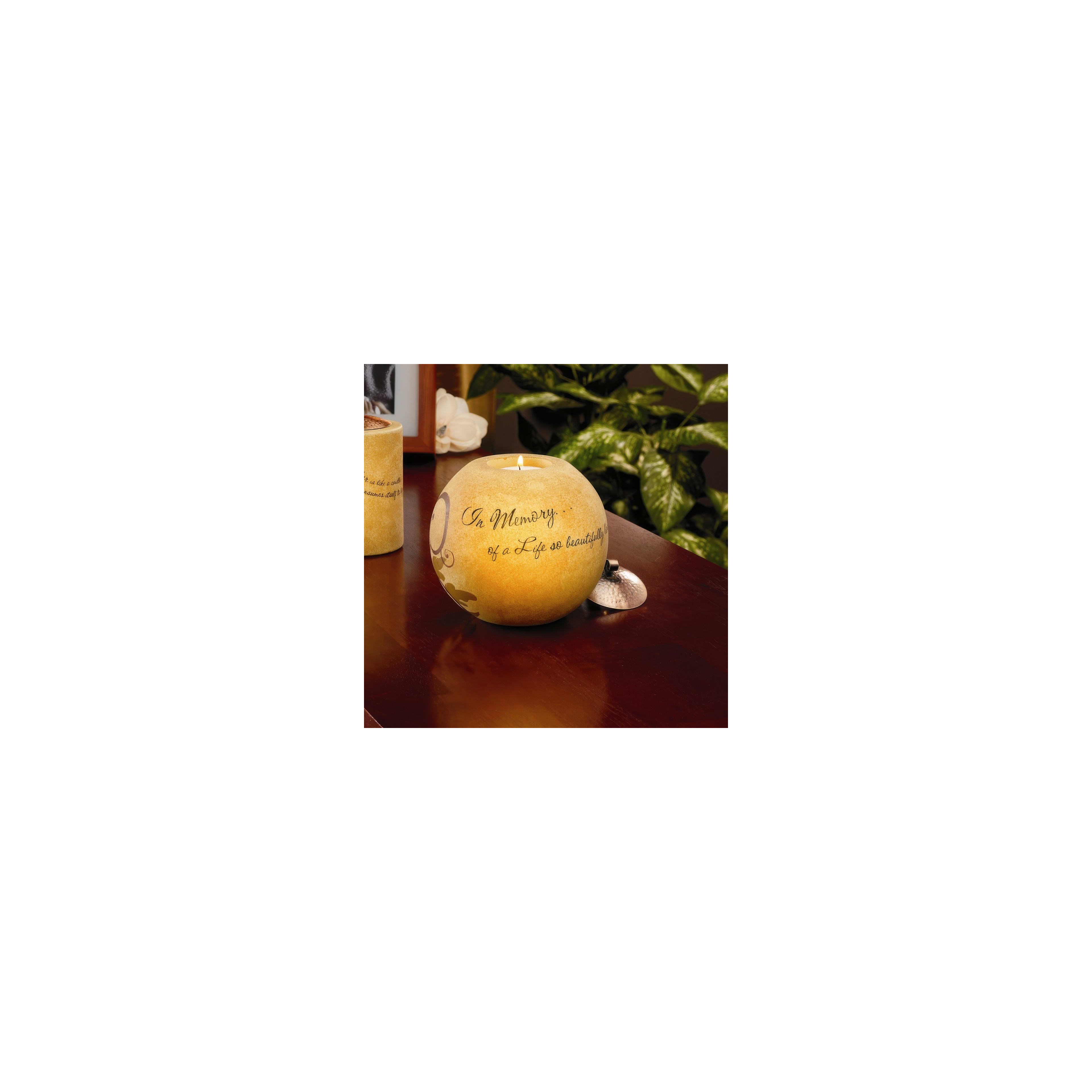 A decorative candle sits on a table, honoring the memory of a loved one with warm light.