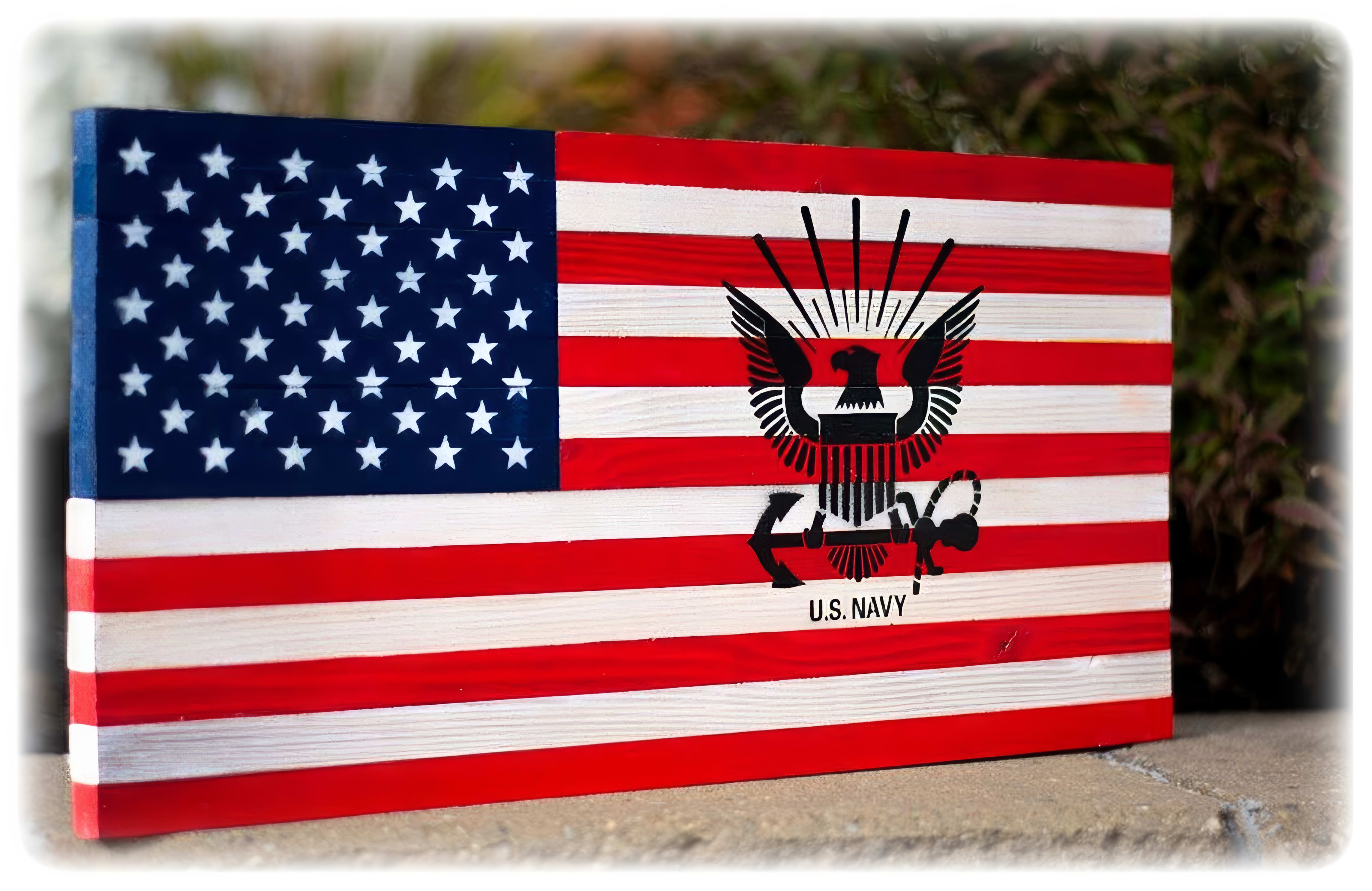 A unique flag showcasing the U.S. Navy emblem is placed on a surface outdoors, featuring graffiti.