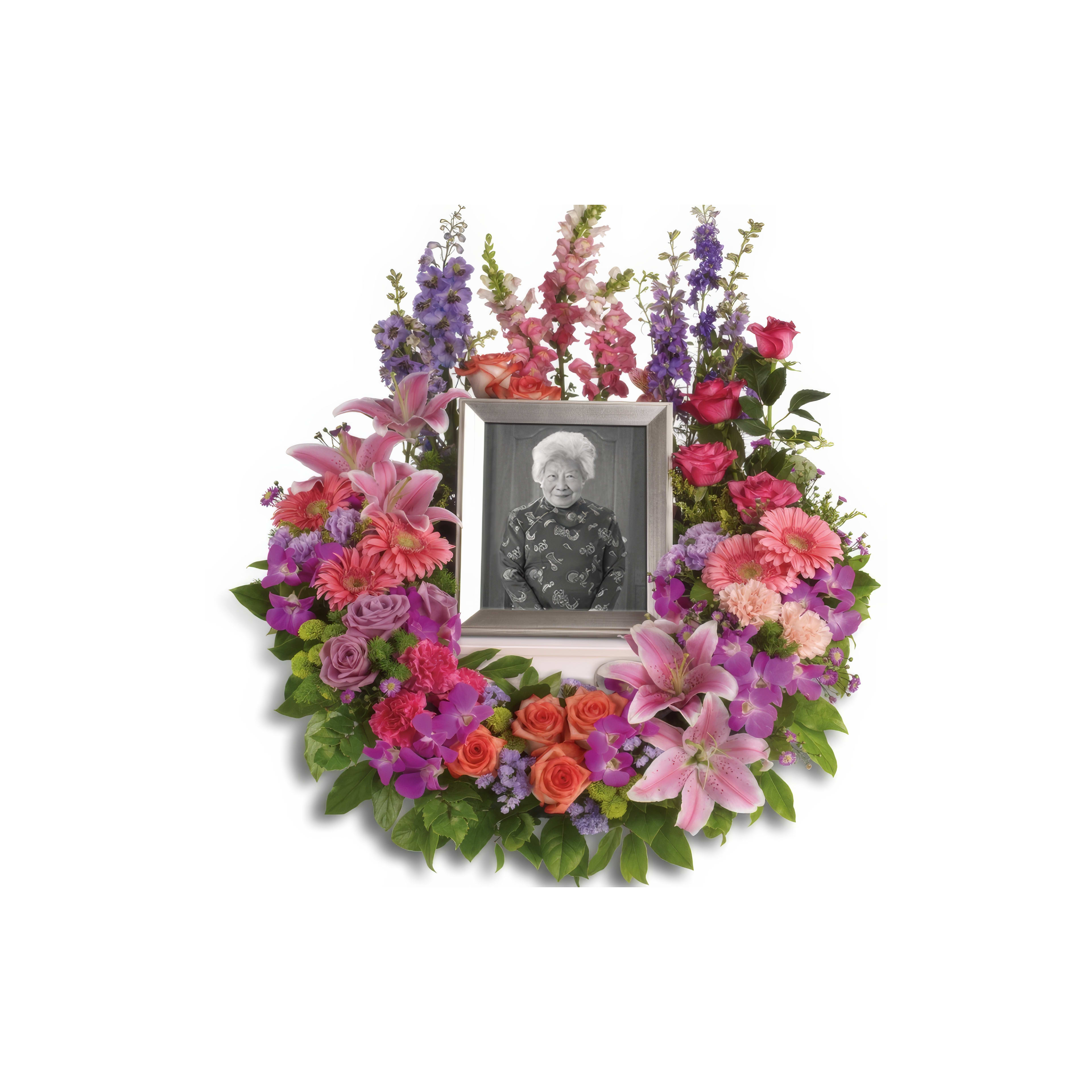 A vibrant wreath of flowers surrounds a framed black-and-white portrait, celebrating a life.