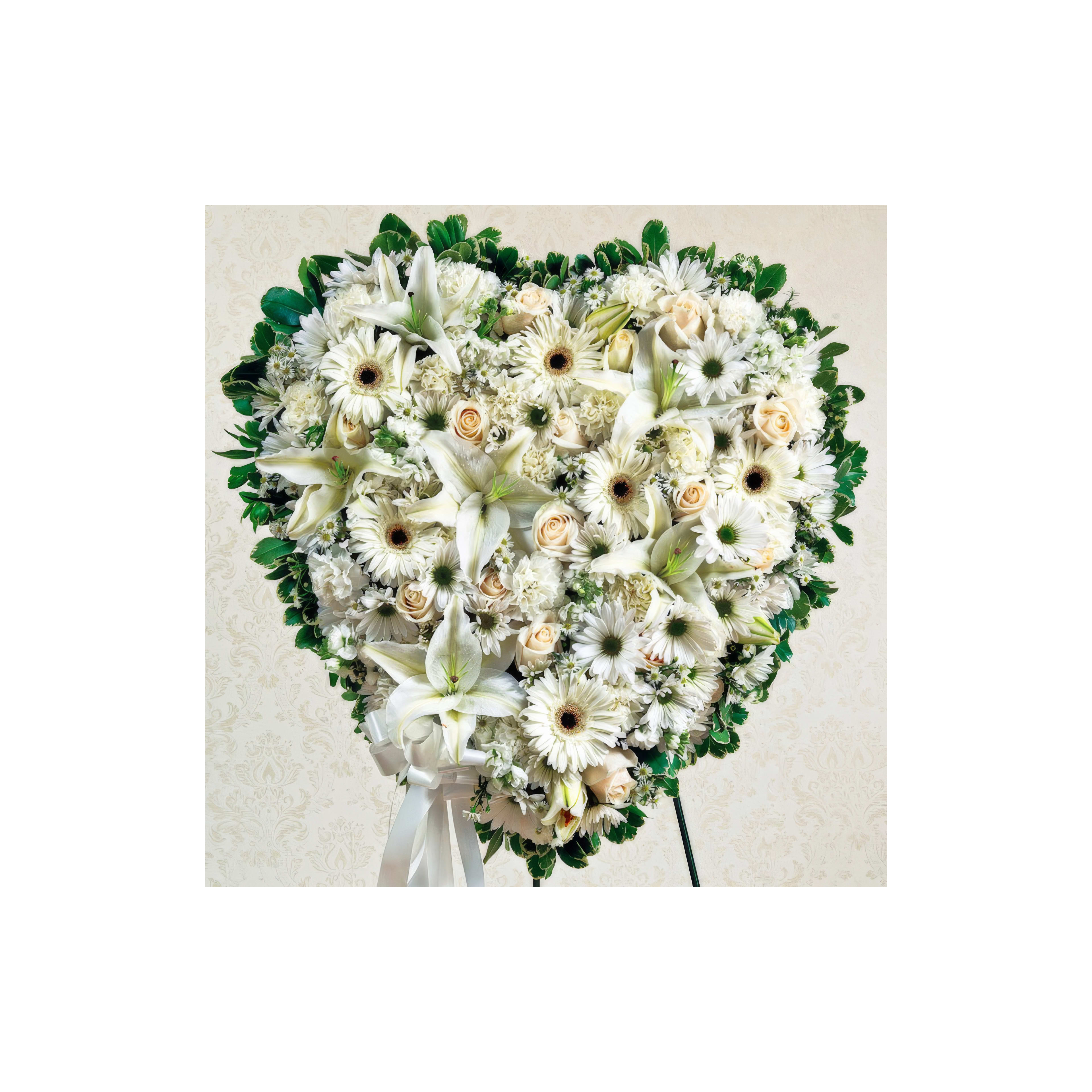 A heart-shaped arrangement of white roses, lilies, and daisies, ideal for celebrations.