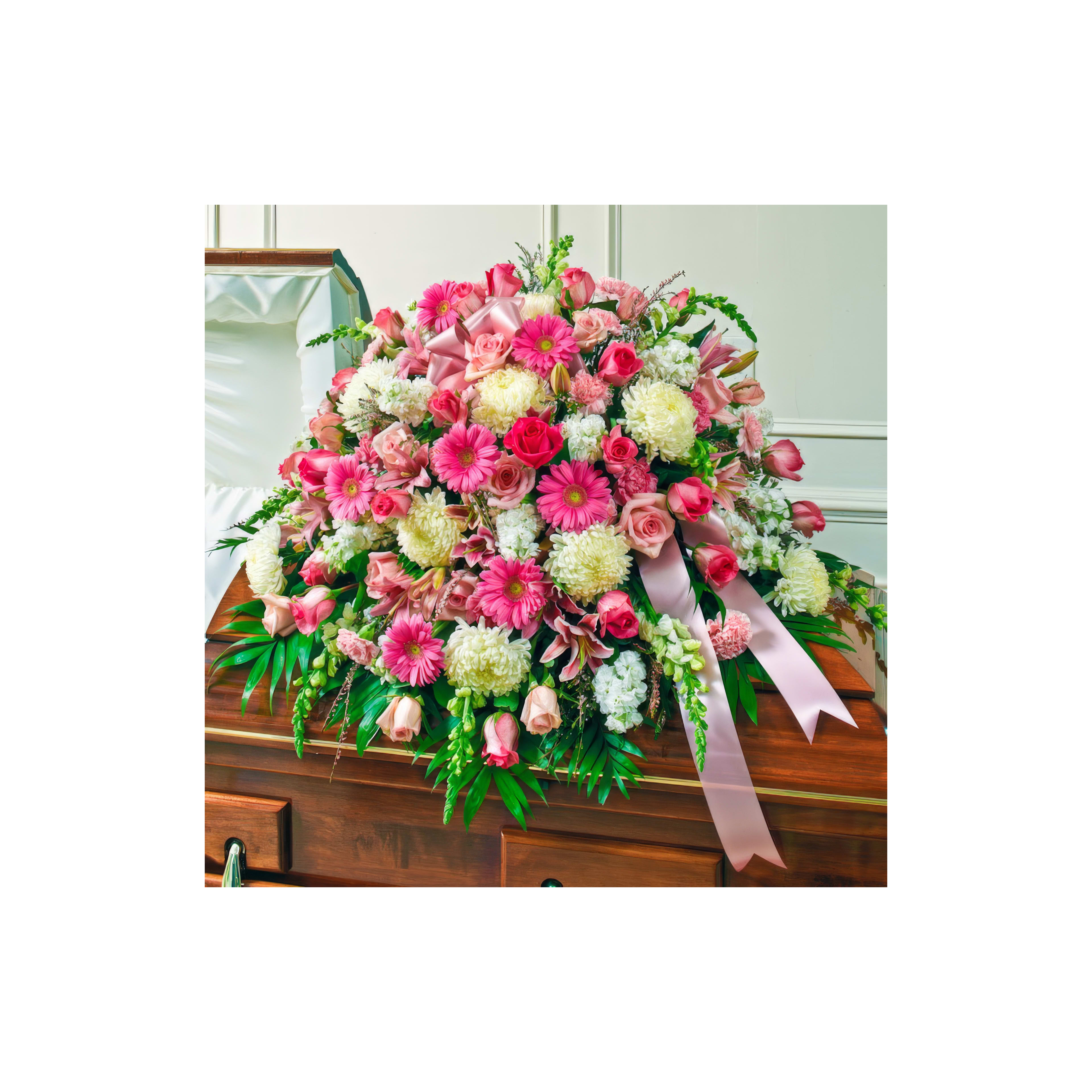 A vibrant bouquet of flowers adorns a wooden casket at a memorial ceremony.