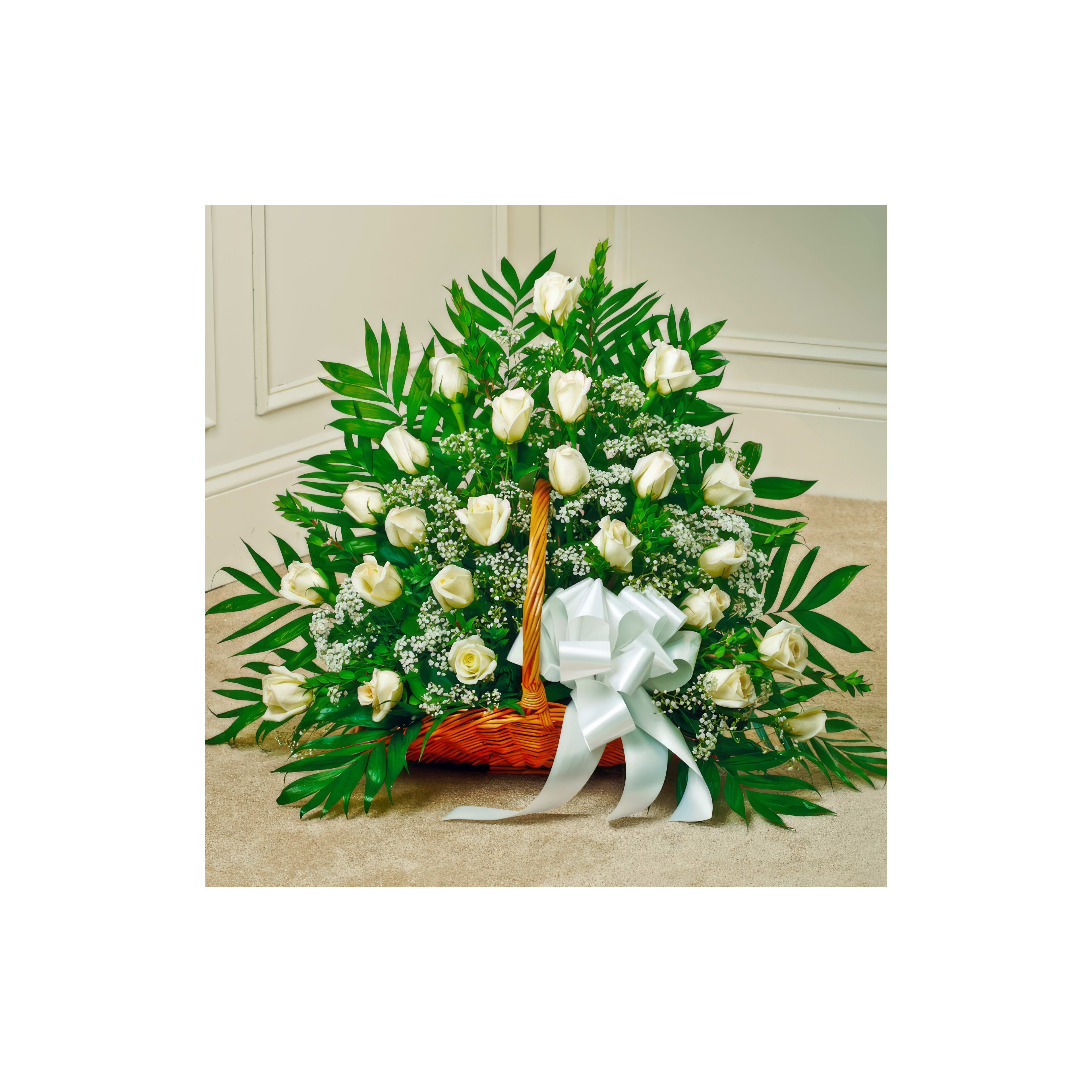 A beautiful arrangement of white roses and greenery in a basket with a decorative bow at a venue.