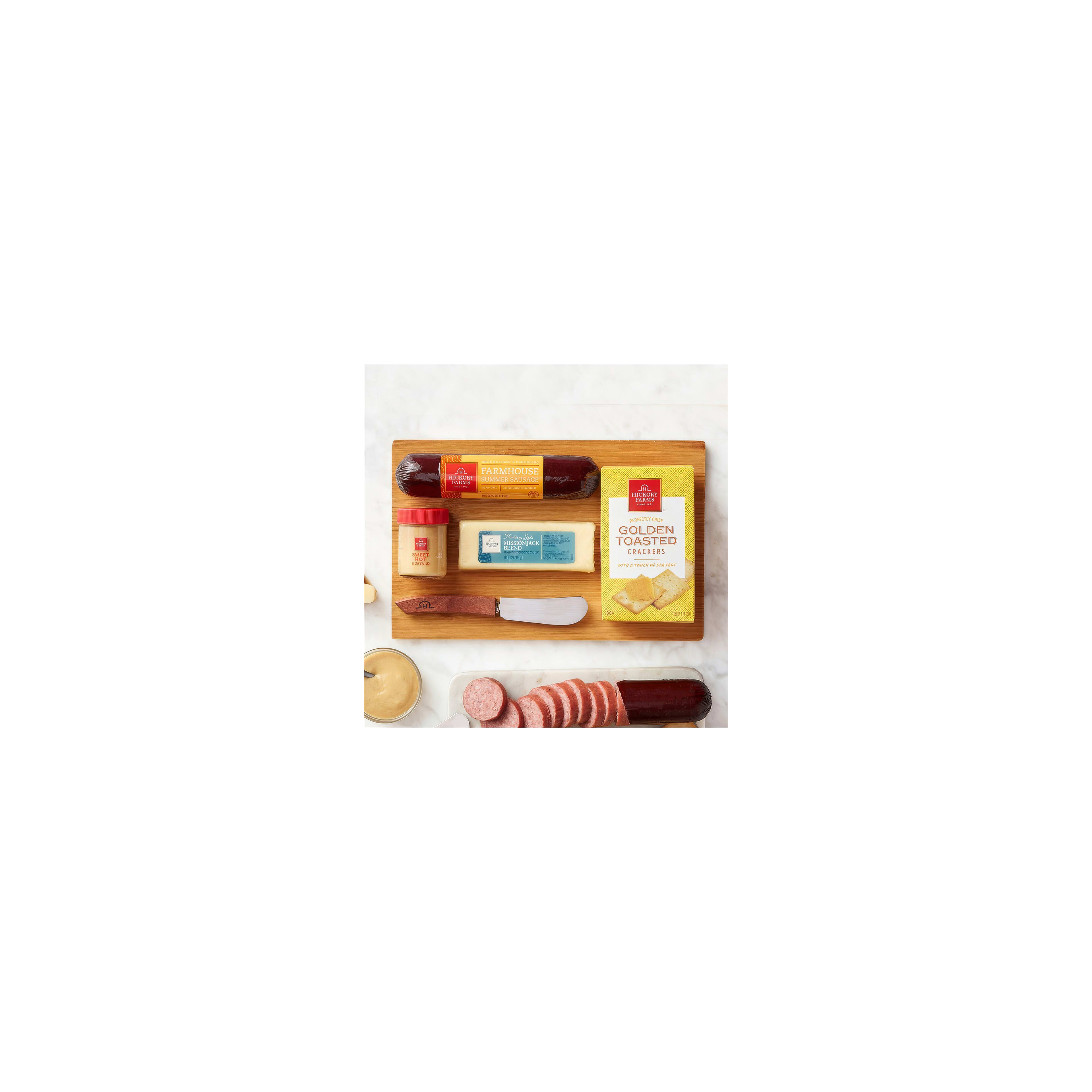 A variety of meats, cheese, crackers, and spread beautifully displayed for a casual gathering.