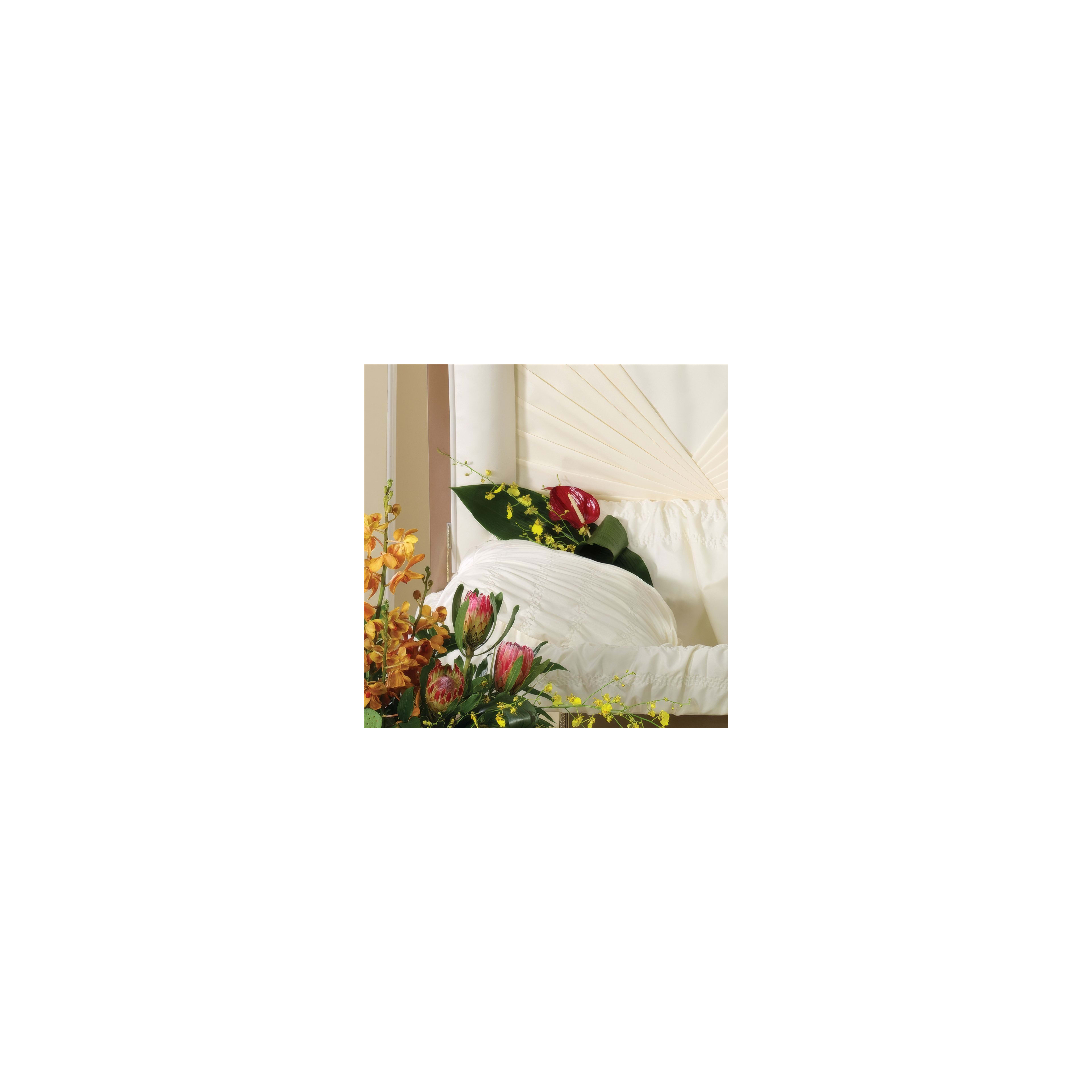 Colorful flowers are arranged gracefully near a peaceful resting place, creating a calm atmosphere.