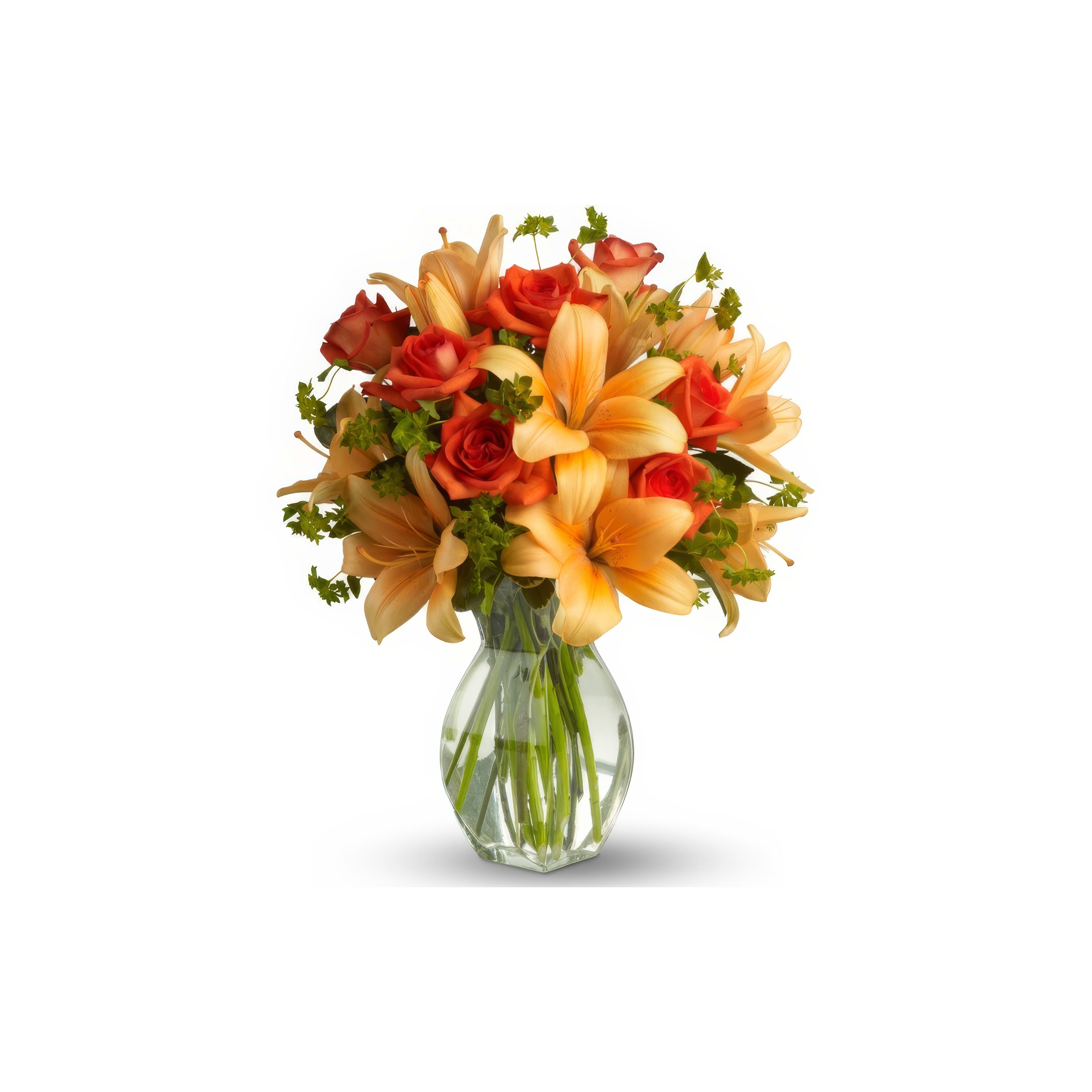 Colorful bouquet features orange lilies and red roses arranged in a clear vase on a table.