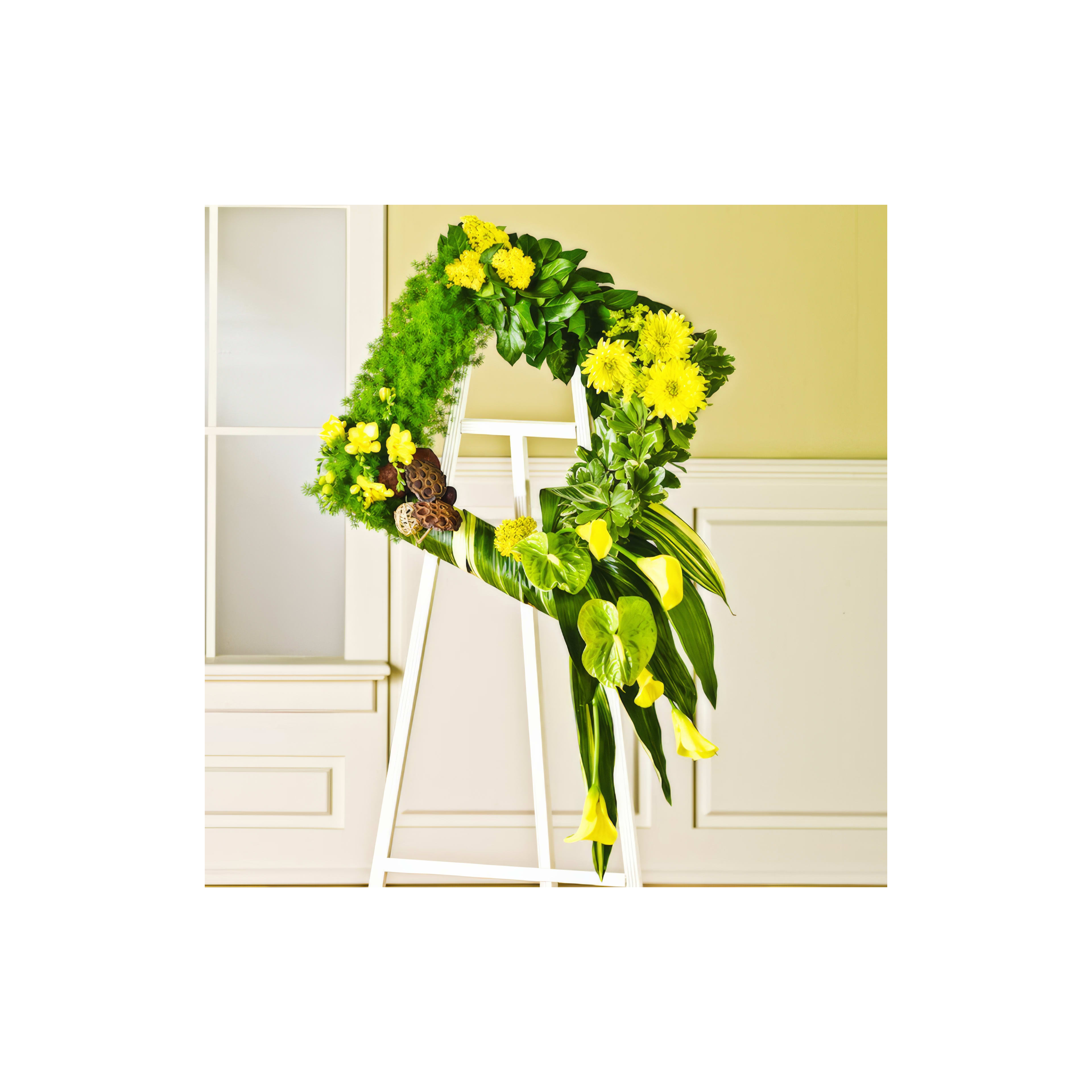 Floral arrangement featuring vibrant yellow flowers and lush greenery displayed indoors at an event.