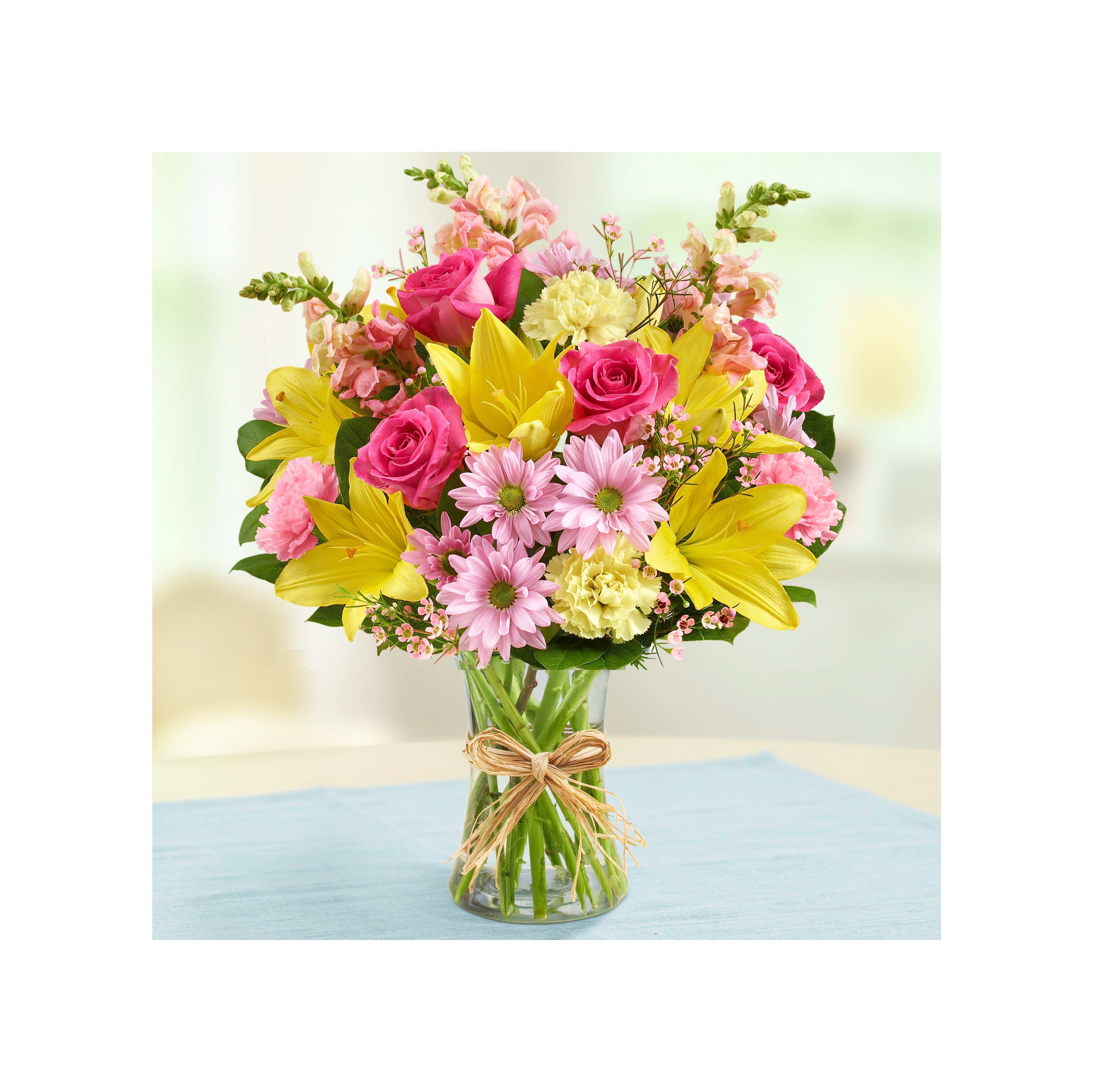 A colorful arrangement of roses, lilies, and daisies in a clear vase brings brightness to the room.