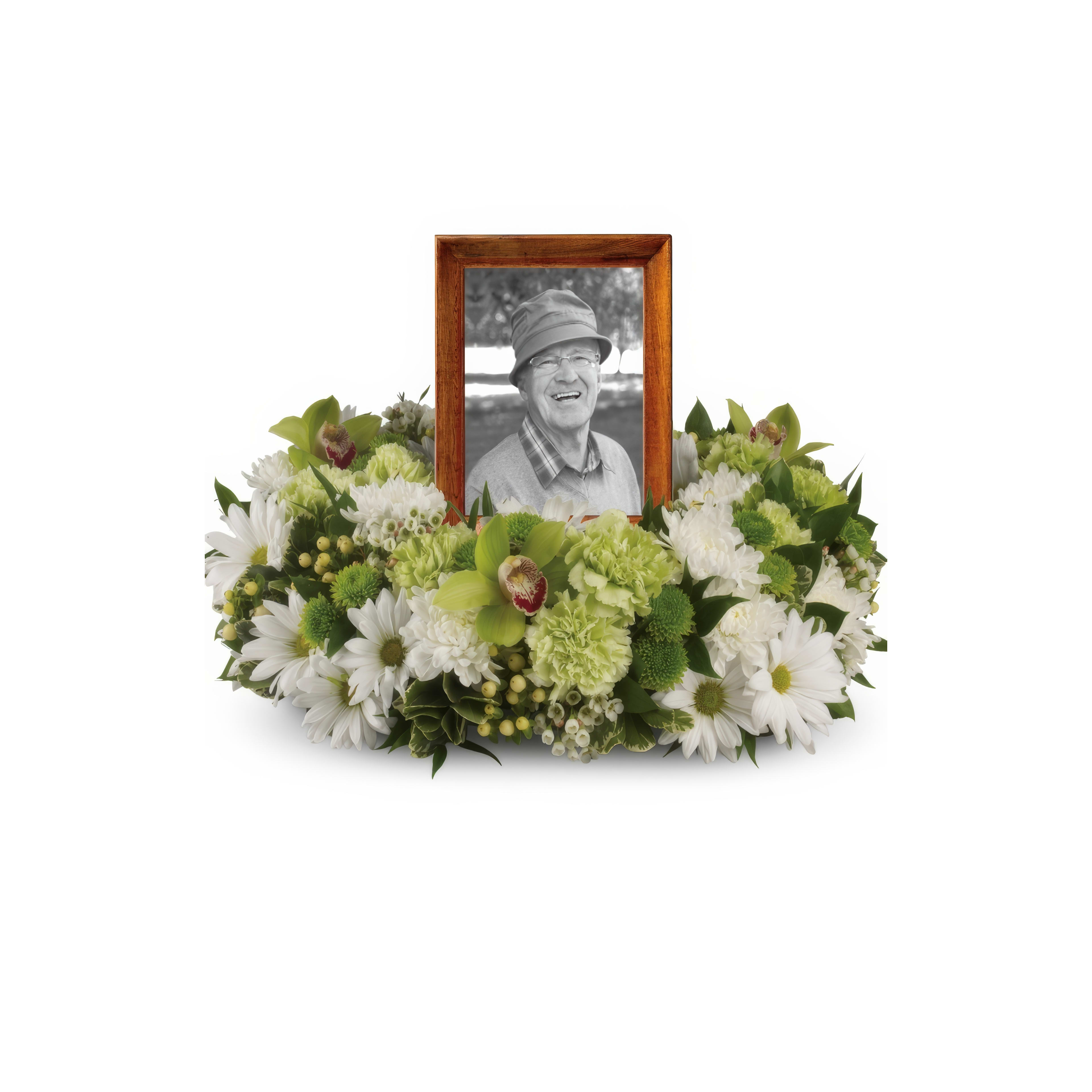 A floral arrangement frames a portrait, evoking fond memories in a serene setting.